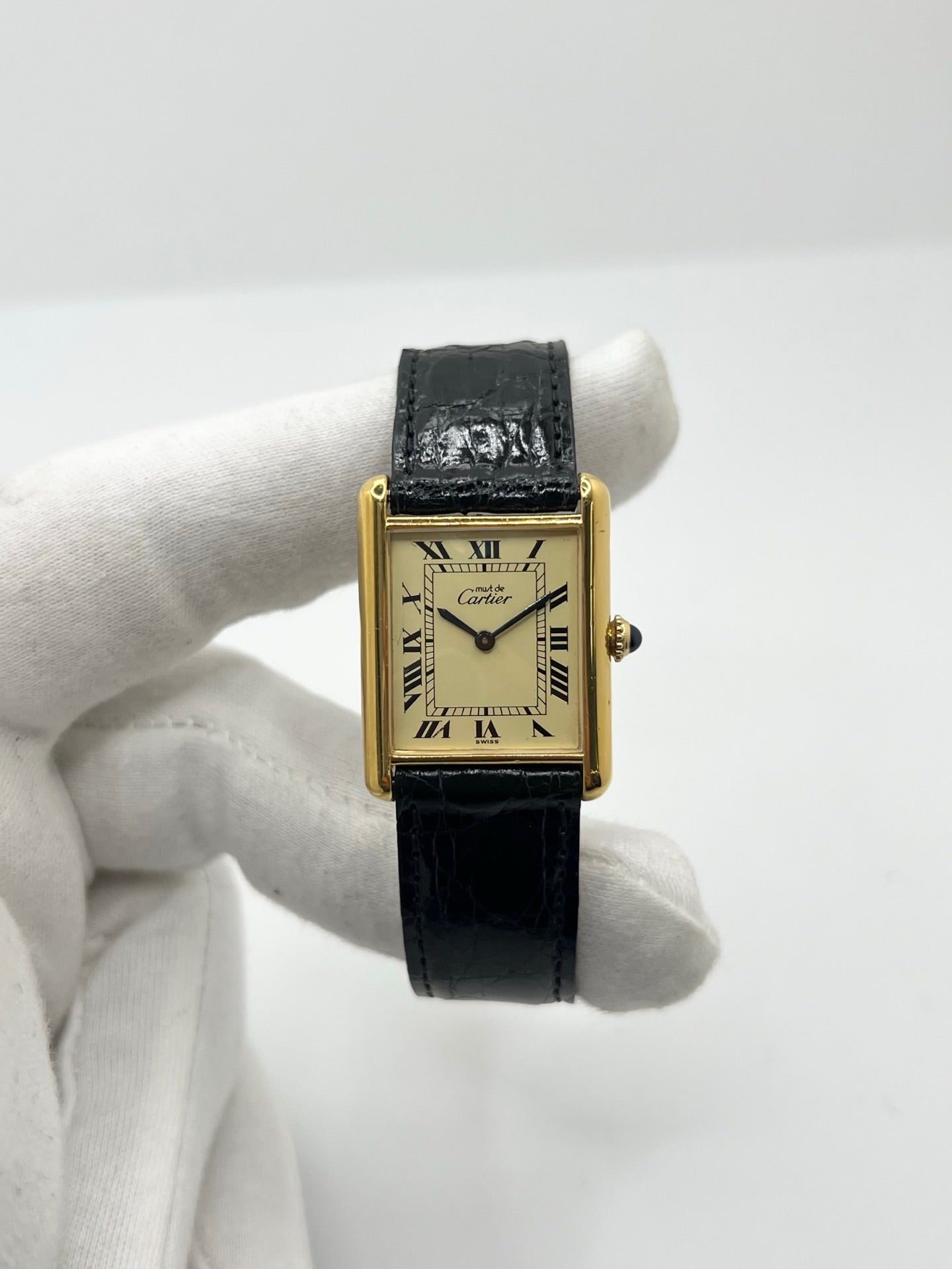 Montre Cartier Tank Vermeil mécanique vintage en argent plaqué or, dotée d’un mouvement à remontage manuel. Ce modèle emblématique présente un cadran champagne à chiffres romains, un boîtier rectangulaire de 23 x 30 mm et un bracelet en cuir de crocodile noir avec boucle ardillon en acier. Élégante et intemporelle, cette montre Cartier Must Tank d’occasion en très bon état séduit les amateurs d’horlogerie classique et de montres de luxe vintage.
