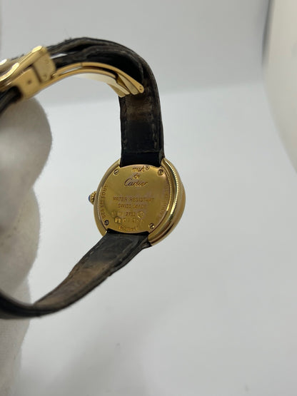 Montre Cartier Trinity référence 2735 pour femme en argent avec boîtier de 27 mm, cadran blanc à chiffres romains et verre saphir. Cette montre Cartier Trinity à mouvement quartz est équipée d’un bracelet en cuir avec boucle déployante en acier. Son design intemporel et élégant en fait une montre de luxe vintage idéale pour les collectionneuses ou pour un usage quotidien. Modèle d’occasion en très bon état, avec de légères traces d’usure, livré avec son coffret d’origine.