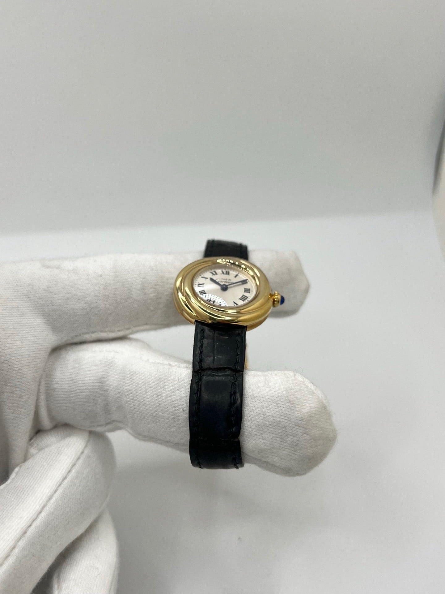 Montre Cartier Trinity référence 2735 pour femme en argent avec boîtier de 27 mm, cadran blanc à chiffres romains et verre saphir. Cette montre Cartier Trinity à mouvement quartz est équipée d’un bracelet en cuir avec boucle déployante en acier. Son design intemporel et élégant en fait une montre de luxe vintage idéale pour les collectionneuses ou pour un usage quotidien. Modèle d’occasion en très bon état, avec de légères traces d’usure, livré avec son coffret d’origine.