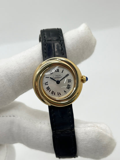 Montre Cartier Trinity référence 2735 pour femme en argent avec boîtier de 27 mm, cadran blanc à chiffres romains et verre saphir. Cette montre Cartier Trinity à mouvement quartz est équipée d’un bracelet en cuir avec boucle déployante en acier. Son design intemporel et élégant en fait une montre de luxe vintage idéale pour les collectionneuses ou pour un usage quotidien. Modèle d’occasion en très bon état, avec de légères traces d’usure, livré avec son coffret d’origine.