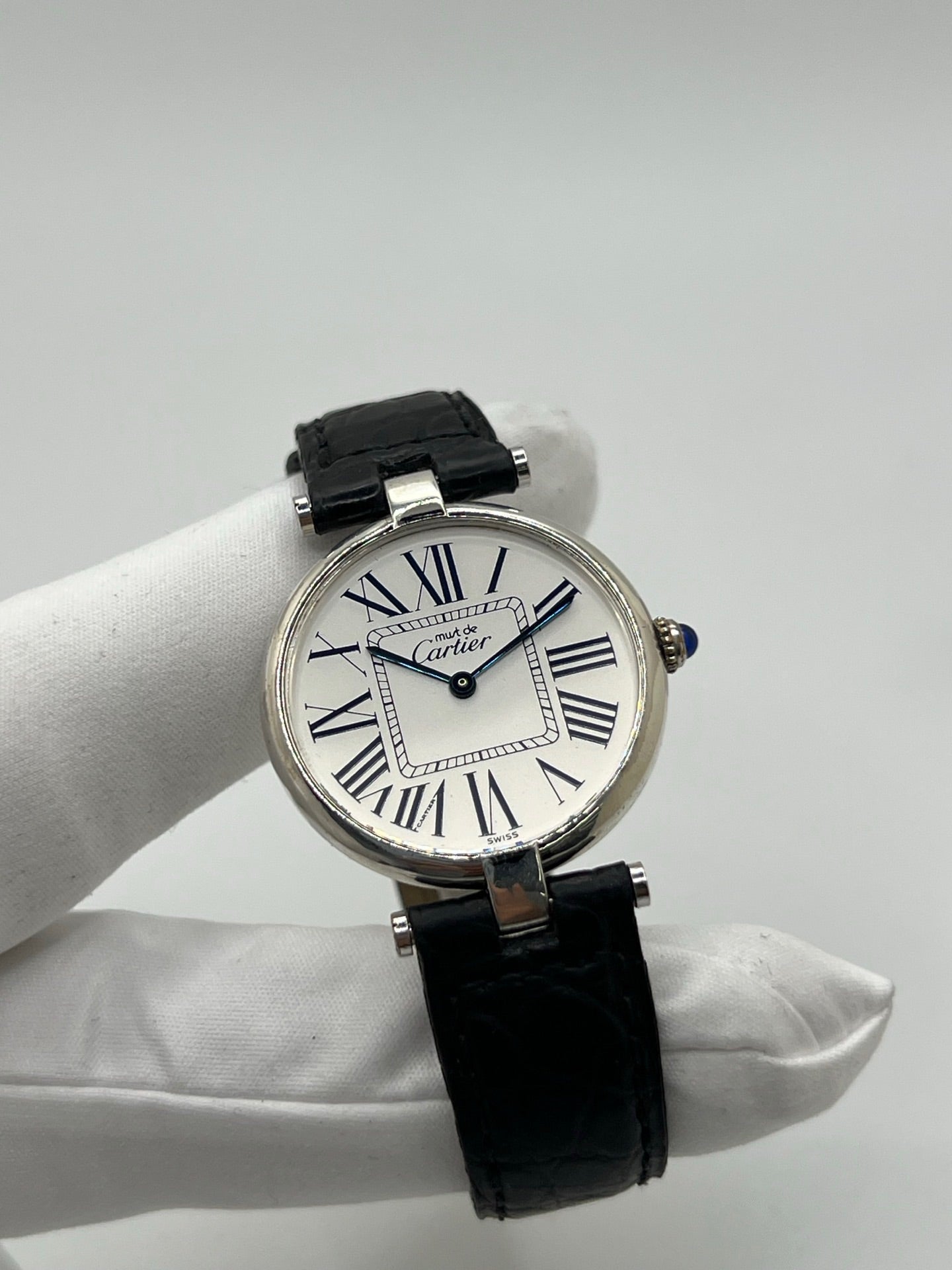 Montre Cartier Must Vendôme référence 1860 avec boîtier rond en argent de 30 mm et cadran argent à chiffres romains signature. Mouvement quartz fiable et élégant, protégé par un verre. Bracelet en cuir noir avec boucle ardillon offrant un porté confortable et raffiné. Modèle emblématique au style classique et intemporel, idéal pour une tenue habillée ou une collection de montres vintage. Montre d’occasion en très bon état, révisée et prête à être portée au quotidien.