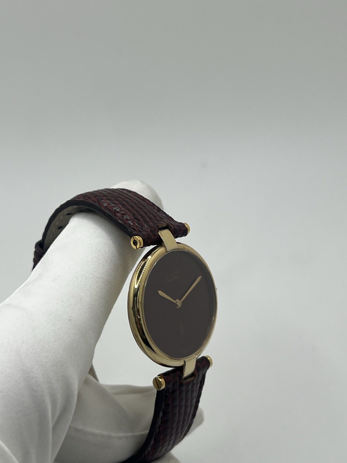 Montre Cartier Must Vendôme Vermeil 30 mm avec cadran bordeaux “burgundy”. Ce modèle vintage emblématique présente un boîtier rond en vermeil (argent plaqué or), un cadran laqué rouge profond signature de la collection Must, des aiguilles dorées élégantes et un design classique intemporel. Montre de luxe suisse recherchée par les collectionneurs, idéale pour les amateurs d’horlogerie vintage et de pièces iconiques au style raffiné.