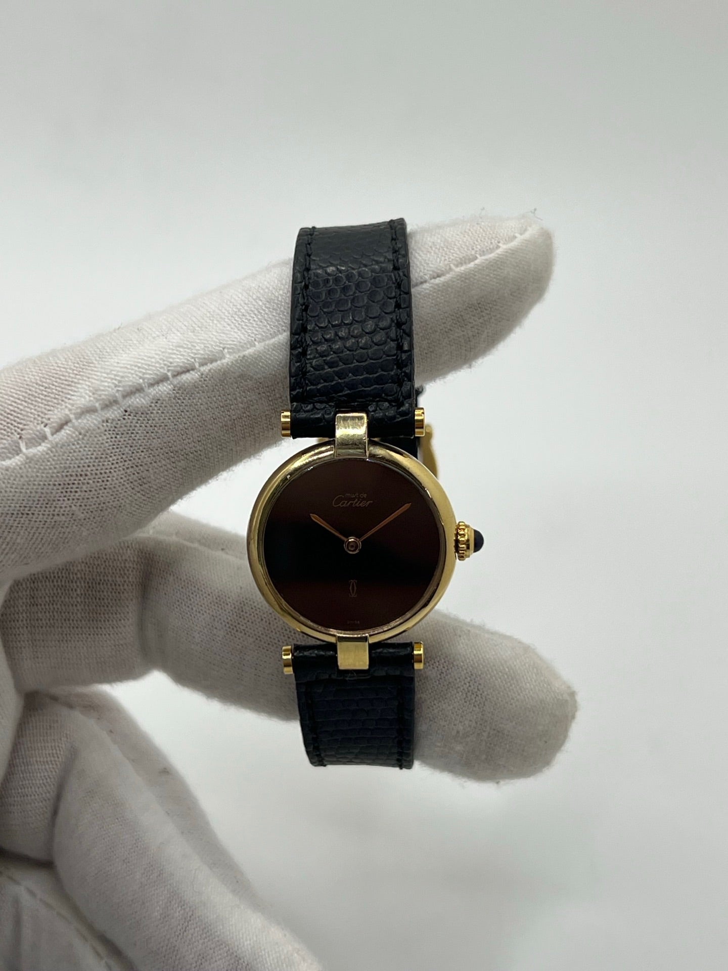 Montre Cartier Must de Cartier Vendome pour femme, boîtier argent de 24 mm avec cadran noir sans chiffres, mouvement quartz précis, verre saphir résistant aux rayures, bracelet cuir noir avec boucle ardillon en acier. État d’occasion très bon, livrée avec coffret d’origine. Élégante et intemporelle, idéale pour collection ou usage quotidien.