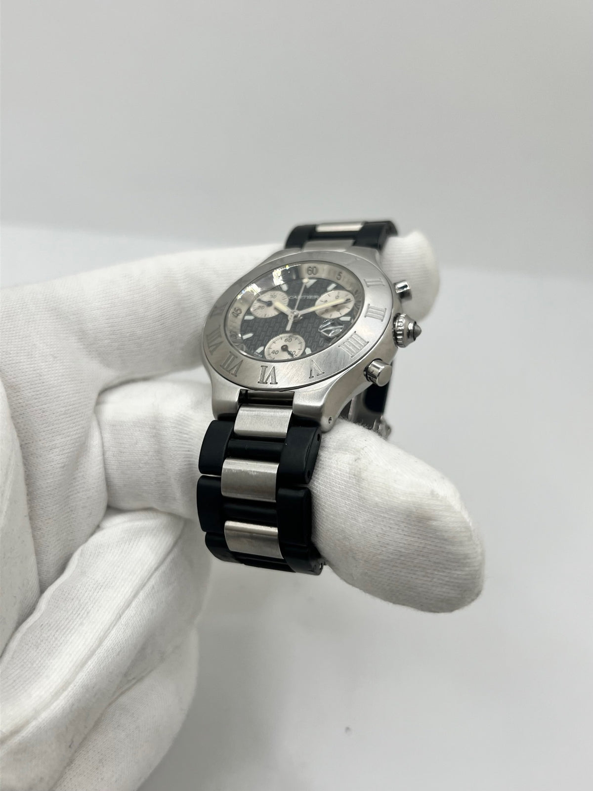 Montre Cartier 21 Chronoscaph 2424 à quartz, dotée d’un boîtier en acier de 38 mm et d’une épaisseur de 10 mm. Son cadran noir est protégé par un verre saphir et accompagné d’un bracelet en caoutchouc avec boucle déployante en acier. Étanche à 10 ATM, cette montre Cartier possède les fonctions chronographe et date. En très bon état, elle présente de légères traces d’usure et a été révisée en interne en septembre 2026.
