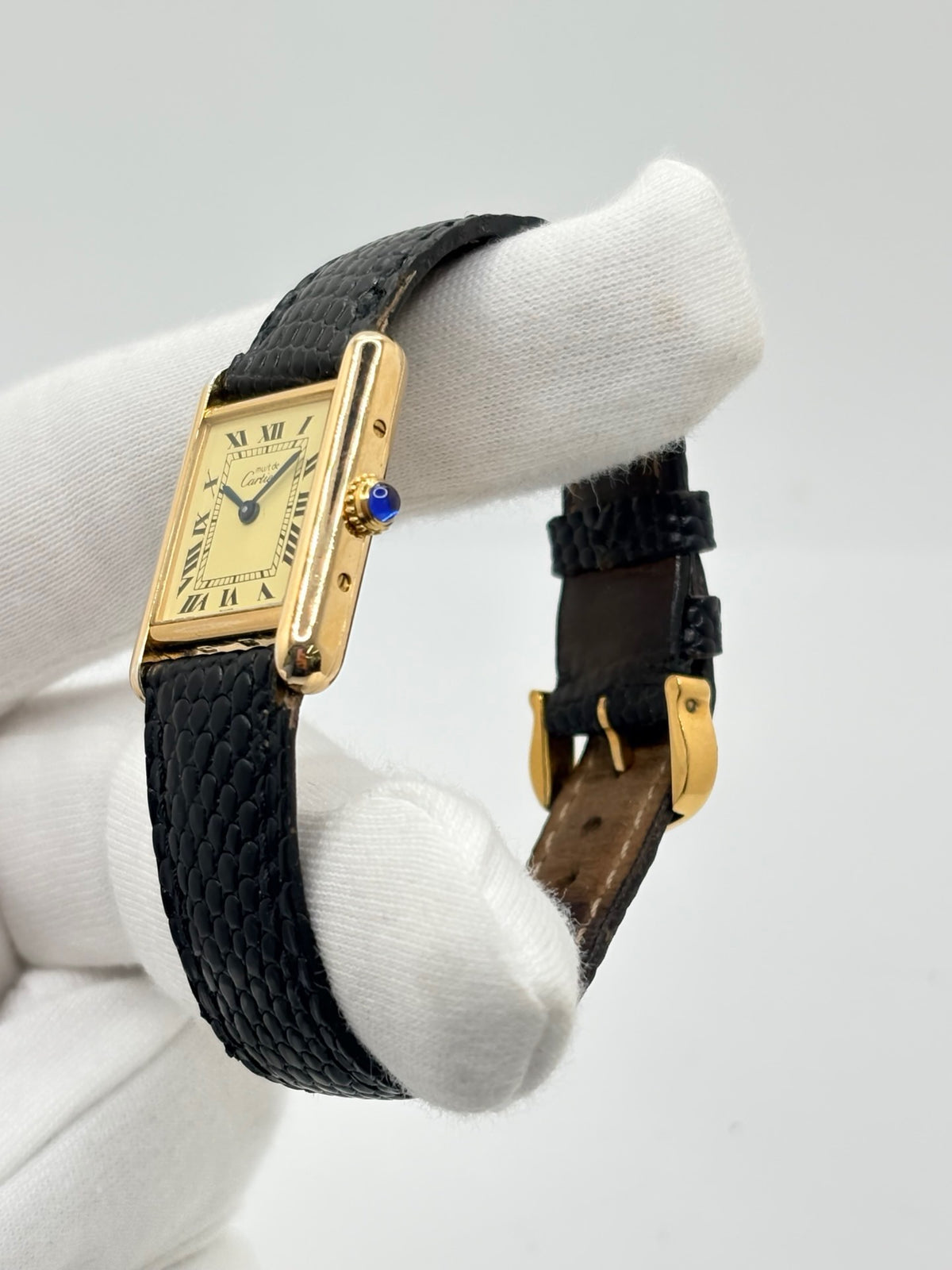 Montre Cartier Tank Vermeil 5057001 en très bon état, équipée d’un mouvement quartz et d’un boîtier en argent de 20 × 28 mm. Son cadran blanc à chiffres romains est protégé par un verre minéral. Cette montre Cartier Tank Vermeil possède un bracelet en cuir de lézard noir avec boucle ardillon en acier. Livrée avec son coffret d’origine, elle séduit par son design élégant et intemporel, emblématique de la collection Tank.
