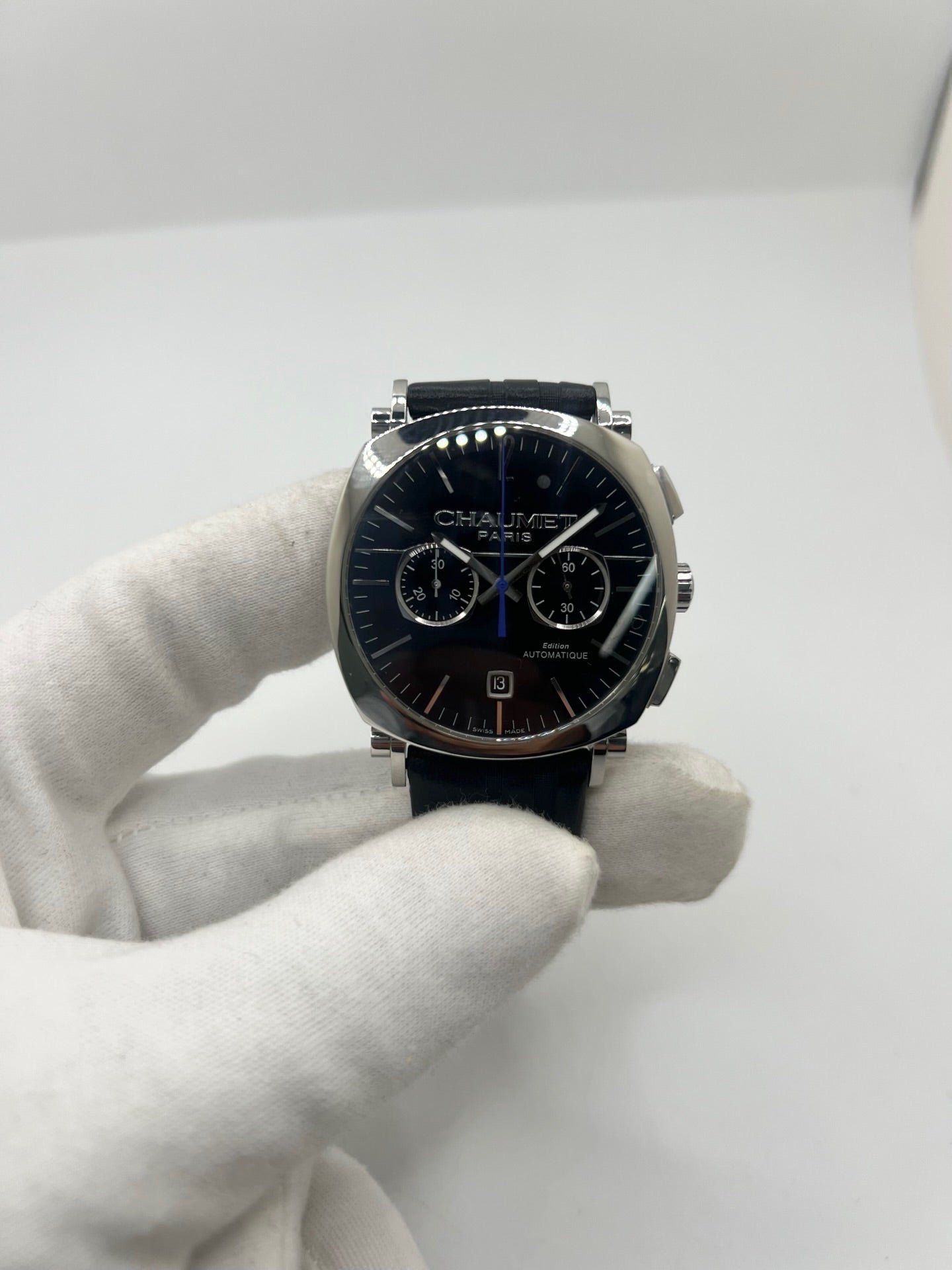 Montre Chaumet Dandy réf. 1229 pour homme ou unisexe, dotée d’un mouvement automatique. Boîtier en acier de 40 mm avec lunette assortie et verre saphir résistant aux rayures. Cadran noir à index bâtons, fonction chronographe et affichage de la date. Bracelet en cuir noir avec boucle déployante en acier. Montre de luxe d’occasion en très bon état, présentant de légères traces d’usure. Révisée en interne le 23 juin 2026, livrée avec coffret d’origine, sans papiers. Disponible à Paris. 