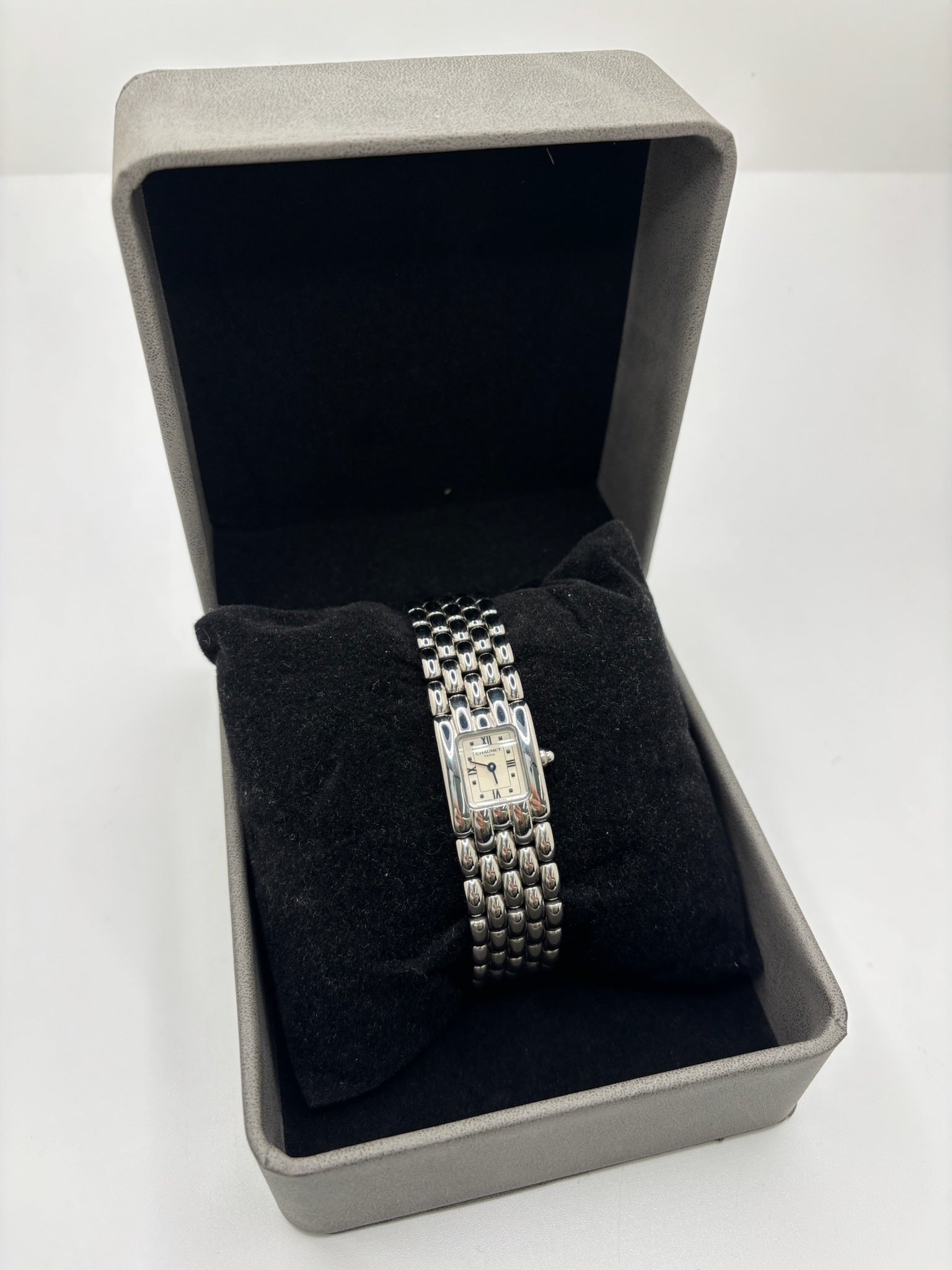Montre Chaumet Khesis femme en acier avec mouvement quartz, cadran blanc à chiffres romains et verre saphir. Cette montre de luxe au design joaillier emblématique se distingue par son boîtier rectangulaire de 21 x 17 mm et son bracelet en acier intégré. Élégante et raffinée, cette Chaumet Khesis vintage de 1998 est accompagnée de ses papiers d’origine. Montre femme d’occasion en très bon état, idéale pour les collectionneuses et amatrices d’horlogerie de prestige.