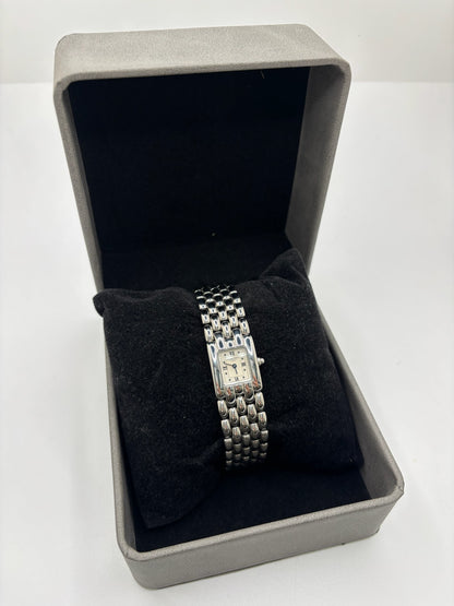 Montre Chaumet Khesis femme en acier avec mouvement quartz, cadran blanc à chiffres romains et verre saphir. Cette montre de luxe au design joaillier emblématique se distingue par son boîtier rectangulaire de 21 x 17 mm et son bracelet en acier intégré. Élégante et raffinée, cette Chaumet Khesis vintage de 1998 est accompagnée de ses papiers d’origine. Montre femme d’occasion en très bon état, idéale pour les collectionneuses et amatrices d’horlogerie de prestige.