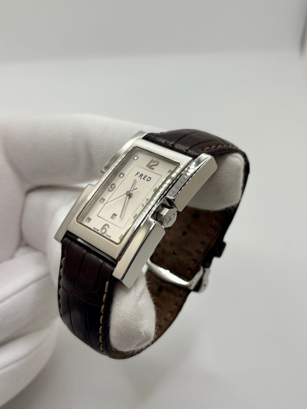 Montre Fred Tank R09-100 en excellent état, dotée d’un mouvement quartz et d’un boîtier en acier de 33 × 27 mm. Cette montre élégante présente un cadran blanc avec chiffres arabes, protégé par un verre saphir. Elle est accompagnée d’un bracelet en cuir brun avec boucle en acier. Modèle homme ou unisexe, cette Fred Tank R09-100 séduit par son design classique et intemporel, idéal pour compléter une tenue élégante au quotidien.

