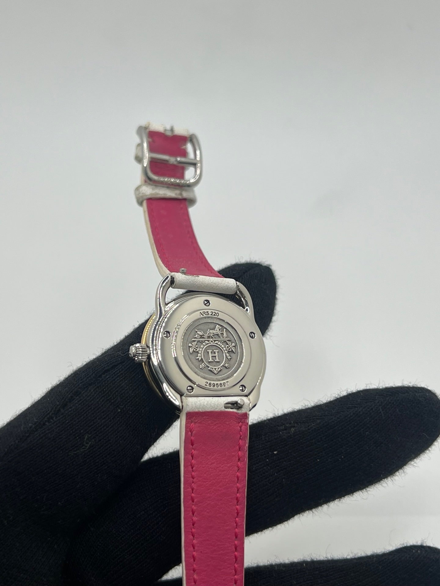 Élégante montre Hermès Arceau pour femme, boîtier en or et acier, cadran blanc aux chiffres arabes et bracelet en cuir beige. Ce garde-temps emblématique allie raffinement et savoir-faire horloger français, offrant un design intemporel et une précision quartz idéale pour un style classique et chic.