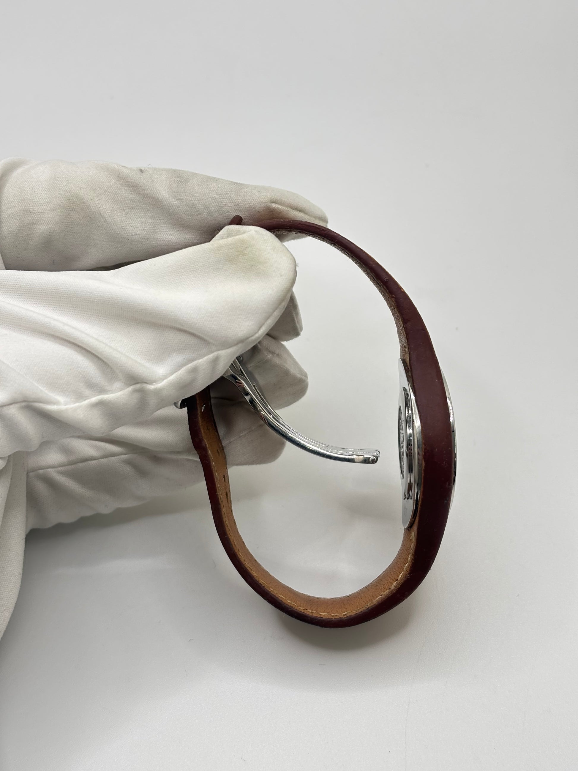 Montre Hermès Harnais HA3.410 en acier avec mouvement quartz, cadran blanc et bracelet en cuir brun. Modèle homme et unisexe au design élégant avec verre saphir et fonction date. Montre d’occasion en très bon état avec légères traces d’usure et micro-rayures discrètes. Format 30 mm idéal pour un style classique et raffiné.
