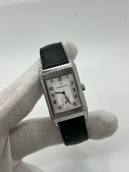 Découvrez la Jaeger-LeCoultre Reverso Grande Taille pour homme/unisexe, modèle 2008 en acier avec bracelet cuir brun. Montre de luxe à remontage manuel, calibre 822, 45 h de réserve de marche, petite seconde et cadran argent. État très bon, avec coffret et papiers d’origine.