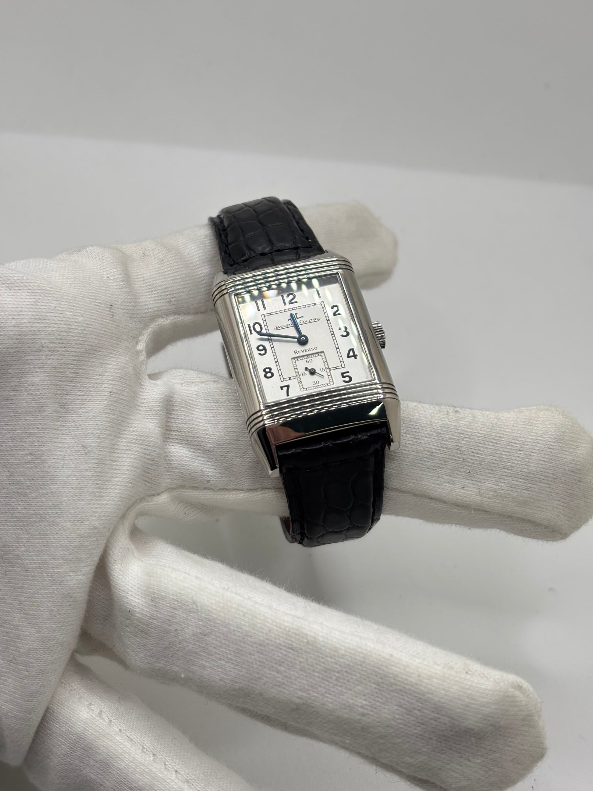 Montre Jaeger-LeCoultre Reverso Grande Taille 270.8.62 en acier, mouvement mécanique à remontage manuel calibre 822. Boîtier rectangulaire 26 x 42 mm, cadran argent à chiffres arabes, petite seconde, verre saphir. Bracelet cuir noir boucle ardillon acier. Modèle 1997 en très bon état, révisé le 4 juin 2026, livré avec coffret et papiers d’origine. Montre de luxe suisse emblématique, design Art déco, style vintage élégant. pièce horlogère iconique.
