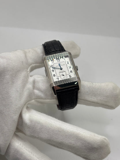 Montre Jaeger-LeCoultre Reverso Grande Taille 270.8.62 en acier, mouvement mécanique à remontage manuel calibre 822. Boîtier rectangulaire 26 x 42 mm, cadran argent à chiffres arabes, petite seconde, verre saphir. Bracelet cuir noir boucle ardillon acier. Modèle 1997 en très bon état, révisé le 4 juin 2026, livré avec coffret et papiers d’origine. Montre de luxe suisse emblématique, design Art déco, style vintage élégant. pièce horlogère iconique.
