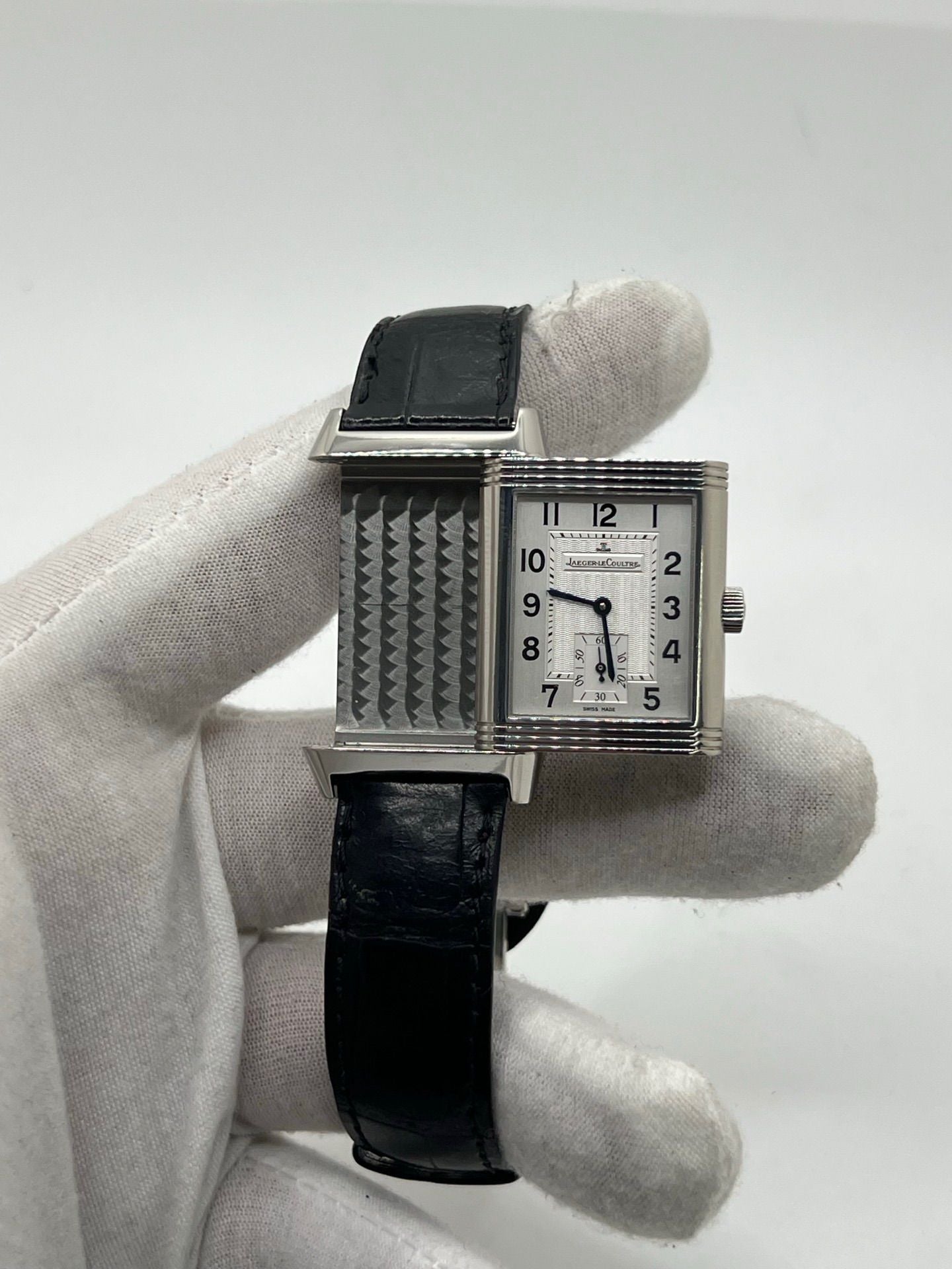 Découvrez la Jaeger-LeCoultre Reverso Grande Taille pour homme/unisexe, modèle 2008 en acier avec bracelet cuir brun. Montre de luxe à remontage manuel, calibre 822, 45 h de réserve de marche, petite seconde et cadran argent. État très bon, avec coffret et papiers d’origine.