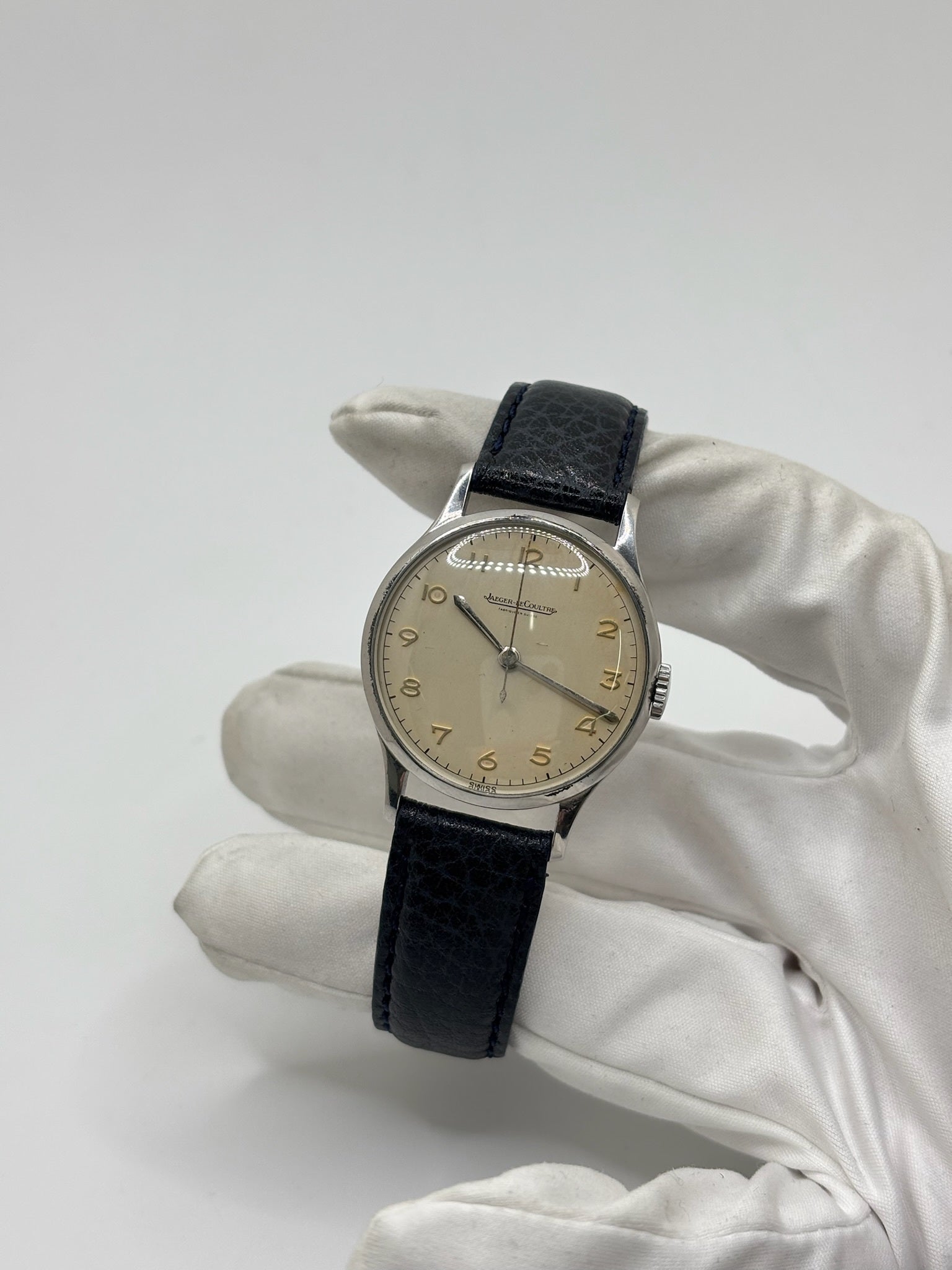 Montre Jaeger-LeCoultre vintage en acier datant des années 1950, équipée du calibre P478 à remontage manuel. Son cadran argent à chiffres arabes est protégé par un verre plexiglas et associé à un bracelet en cuir noir. Avec son boîtier de 31,5 mm et son design sobre et élégant, cette montre mécanique de collection illustre le savoir-faire horloger suisse de l'époque. Pièce ancienne recherchée par les amateurs de montres vintage et de garde-temps de caractère.