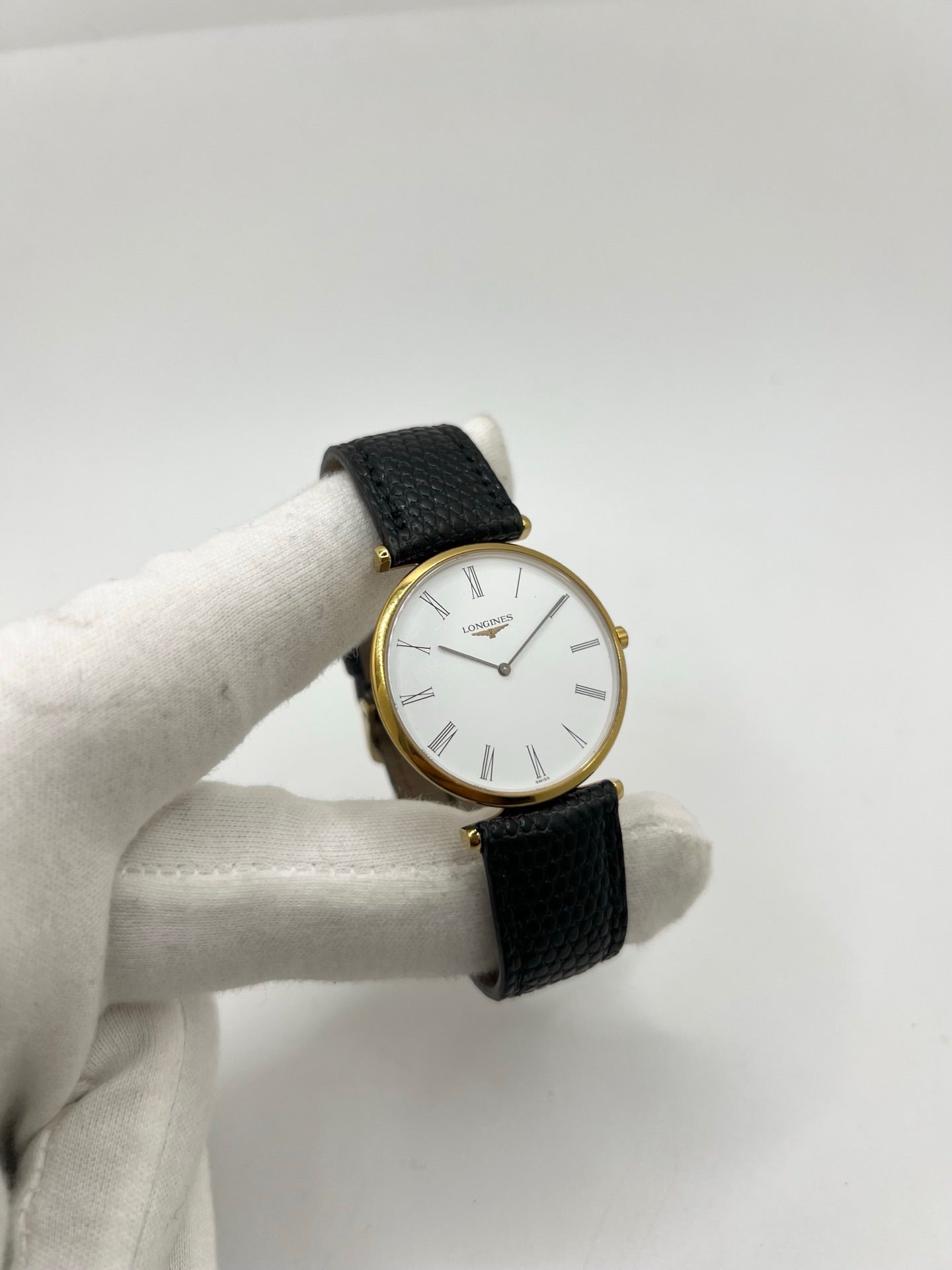 Montre Longines La Grande Classique référence L4.709.2 en plaqué or avec boîtier de 33 mm, cadran blanc à chiffres romains et verre saphir. Ce modèle à mouvement quartz est équipé d’un bracelet en cuir noir avec boucle ardillon en acier. Son design élégant et intemporel en fait une montre de ville raffinée, adaptée aussi bien aux hommes qu’aux amateurs de montres classiques. Pièce d’occasion en très bon état, révisée et prête à être portée.
