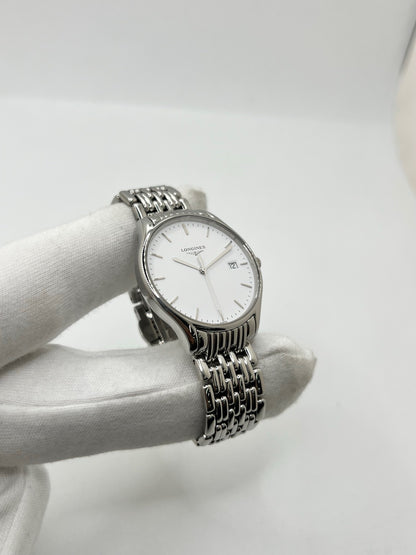 Montre Longines Lyre L43594126 en acier, équipée d’un mouvement à quartz et d’un boîtier de 32 mm. Son cadran blanc élégant est protégé par un verre saphir, offrant une bonne résistance aux rayures. Cette montre Longines Lyre se distingue par son design classique et intemporel, idéal pour accompagner toutes les occasions. Son bracelet en acier assorti, doté d’une boucle déployante double, apporte une finition harmonieuse et raffinée. Modèle de 2018, livré avec son coffret et ses papiers d’origine.
