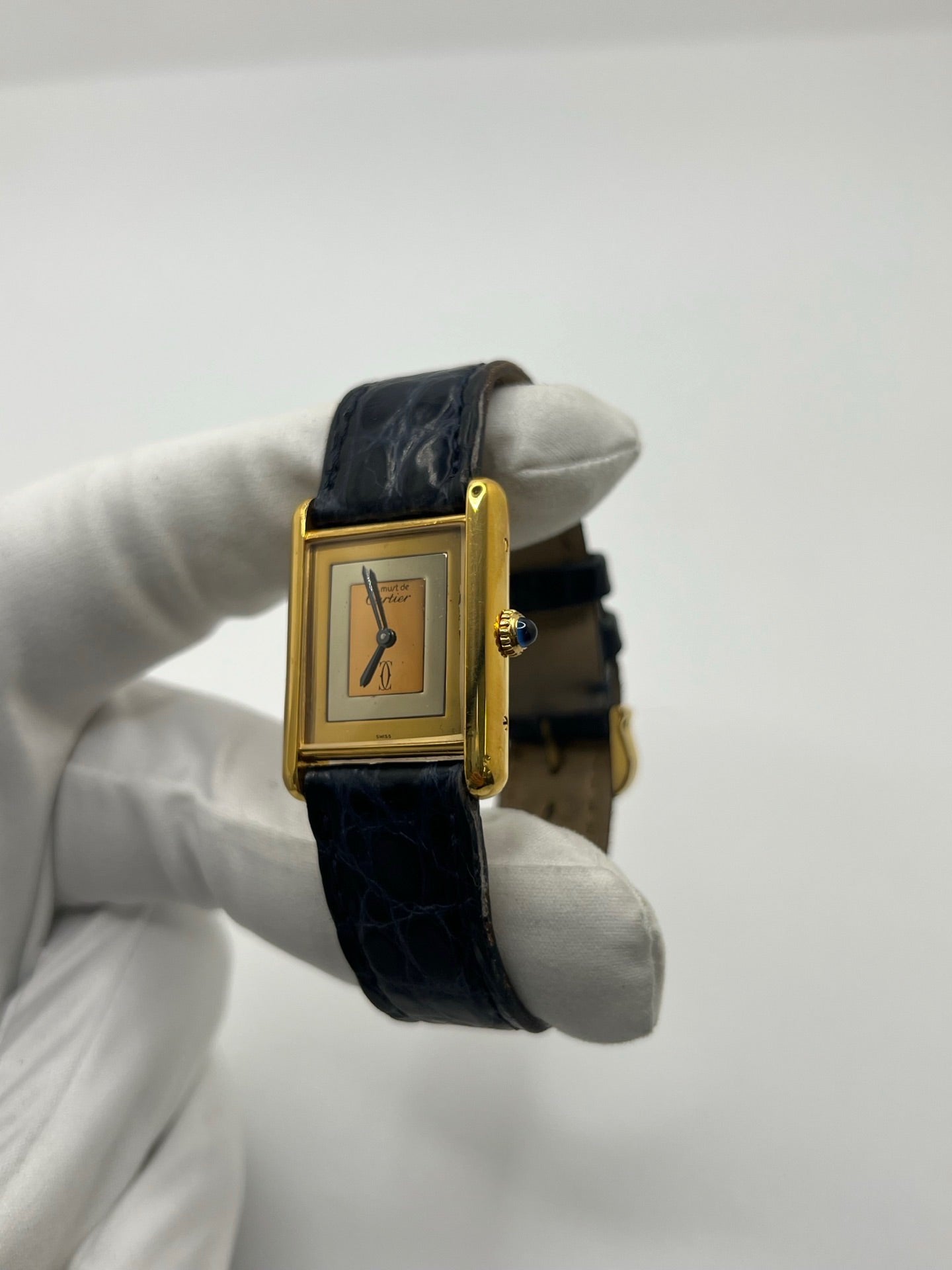 Montre Cartier Must de Cartier Tank Trinity en argent, à remontage manuel, avec boîtier de 23 x 30 mm et cadran jaune sans chiffres. Ce modèle emblématique est équipé d’un bracelet en cuir bleu avec boucle ardillon en acier, d’un verre minéral et d’une lunette en argent. Montre de luxe vintage homme ou unisexe, d’occasion en bon état, présentant des traces d’usure visibles. Révisée en interne, livrée avec coffret d’origine, idéale pour les collectionneurs de montres Cartier Tank Trinity.