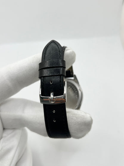 Montre Omega Genève 135.041 vintage de 1969, équipée d’un mouvement à remontage manuel avec calibre 601, offrant une réserve de marche de 48 heures. Son boîtier en acier de 34 mm est associé à un cadran argent à index bâtons, protégé par un verre Plexiglas. Cette Omega Genève est montée sur un bracelet noir en cuir de vache avec boucle ardillon en acier. En bon état, elle présente des traces d’usure visibles.