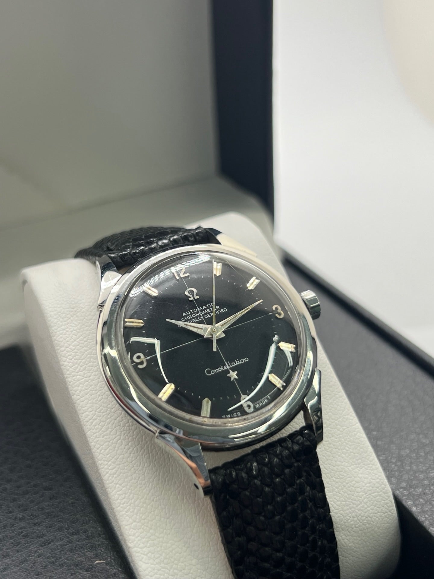 Montre Omega Constellation vintage réf. 2852 9SC des années 1950, équipée d’un mouvement automatique et présentée dans un boîtier acier de 35 mm non poli conservant ses lignes d’origine. Son rare cadran noir d’origine offre une élégance intemporelle, sublimée par des aiguilles au tritium patinées. Le fond Constellation emblématique rappelle l’excellence chronométrique de la collection. Révisée récemment, cette montre de collection est montée sur un bracelet en lézard noir.
