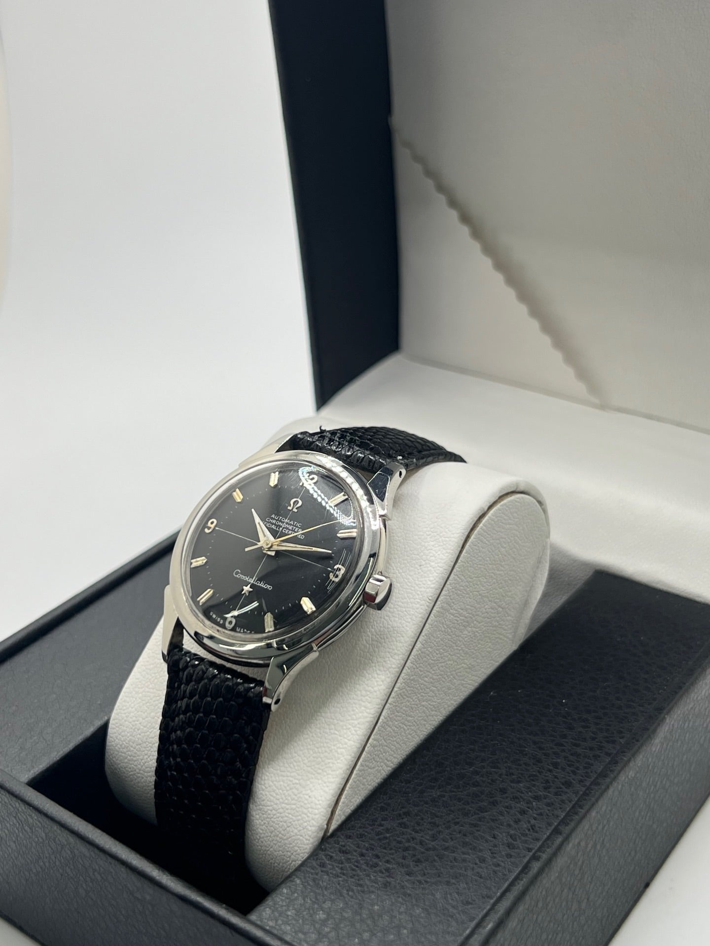 Montre Omega Constellation vintage réf. 2852 9SC des années 1950, équipée d’un mouvement automatique et présentée dans un boîtier acier de 35 mm non poli conservant ses lignes d’origine. Son rare cadran noir d’origine offre une élégance intemporelle, sublimée par des aiguilles au tritium patinées. Le fond Constellation emblématique rappelle l’excellence chronométrique de la collection. Révisée récemment, cette montre de collection est montée sur un bracelet en lézard noir.
