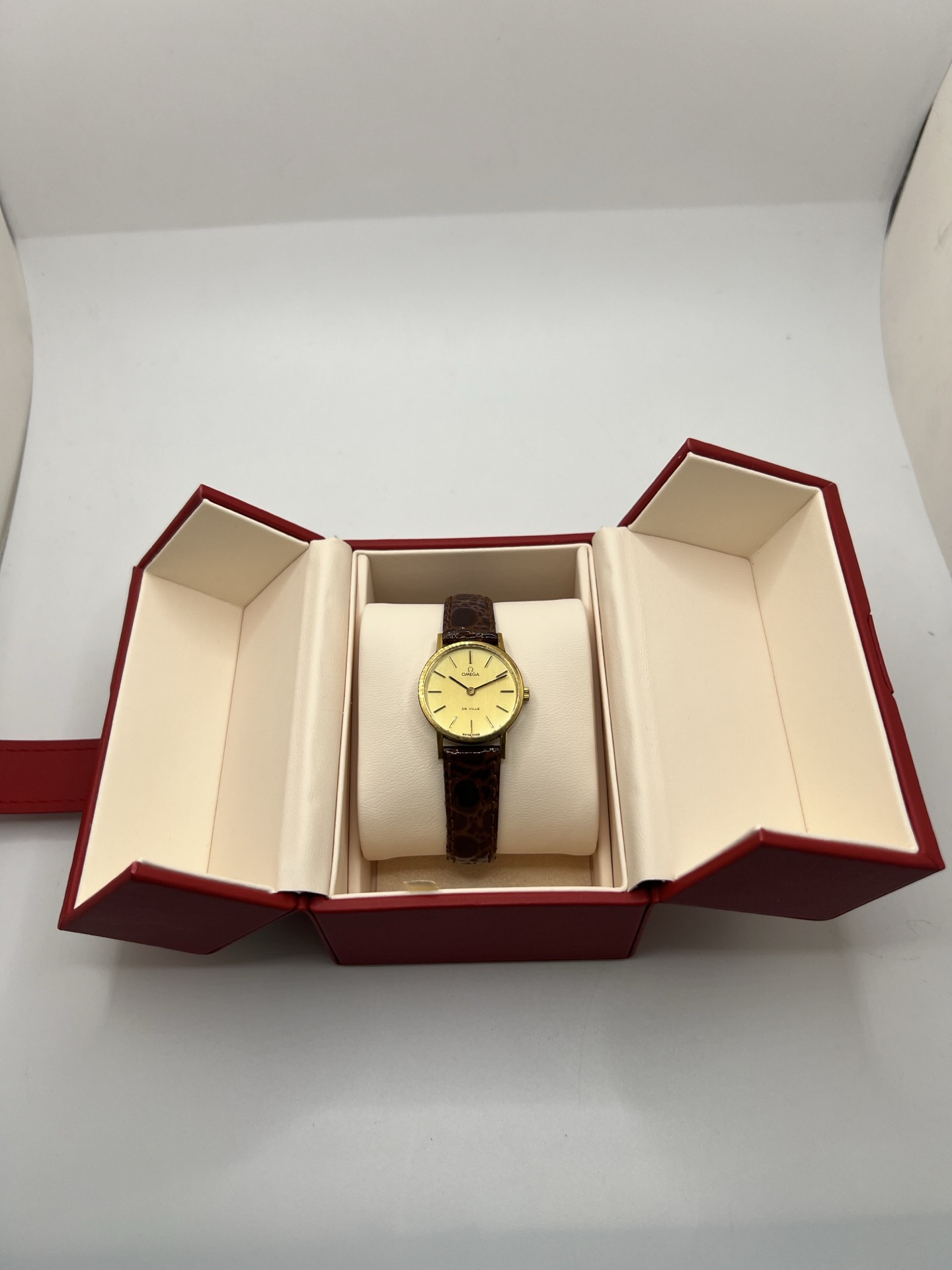 Montre Omega De Ville 511.0392 vintage de 1973 en acier plaqué or avec cadran doré et bracelet cuir brun. Cette Omega Seamaster De Ville mécanique de 24 mm est équipée du calibre Omega 625 à remontage manuel, apprécié pour son charme horloger authentique. Élégante et raffinée, cette Omega vintage femme séduit par son style intemporel inspiré des années 70. Montre révisée avec boucle Omega d’origine, boîte Omega et certificat d’authenticité.