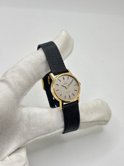Montre Omega De Ville vintage référence 511.0508 pour femme, datant de 1967, avec boîtier en acier de 24 mm et cadran gris à index bâtons. Cette montre à remontage manuel est équipée du calibre Omega 625 à 17 rubis et est montée sur un bracelet en cuir noir avec boucle ardillon en acier. Révisée et en très bon état, elle présente de légères traces d'usure conformes à son âge. Une montre de collection au design élégant, idéale pour les amateurs d'horlogerie vintage.