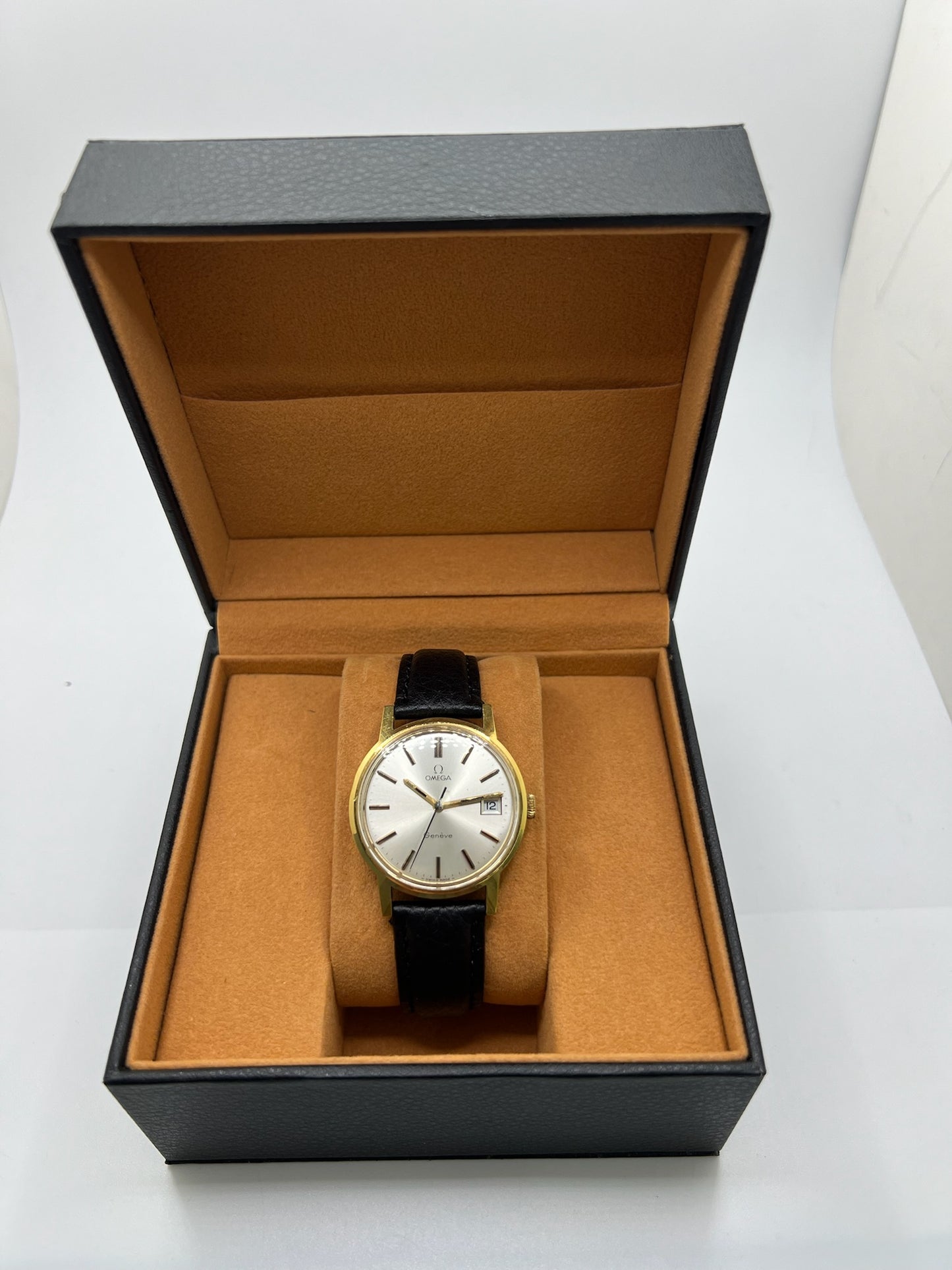 Montre Omega Genève vintage de 35 mm associant or et acier, au design classique et élégant. Cadran doré sobre offrant une lecture claire, complété par un affichage de la date. Boîtier équilibré et proportions harmonieuses, animé par un mouvement mécanique à remontage manuel révisé en interne. Bracelet en cuir noir apportant contraste et confort au poignet. Modèle en bon état d’usage, présentant des traces d’usure visibles telles que rayures, éraflures et petites marques liées à son âge et à son histoire.