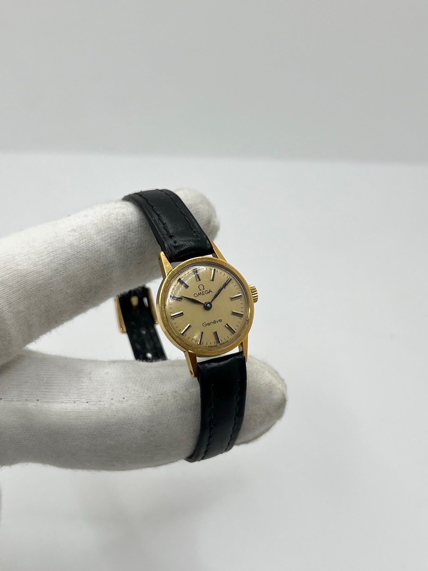 Montre Omega Genève référence 511.0451 pour femme, fabriquée en 1969, avec boîtier en acier de 17 mm et mouvement à remontage manuel. Son élégant cadran argent apporte une touche vintage intemporelle, protégé par un boîtier sobre et raffiné. Elle est montée sur un bracelet en cuir noir avec boucle ardillon en acier. Cette montre Omega d'occasion est en très bon état, révisée en interne et constitue une pièce de collection idéale pour les amateurs d'horlogerie vintage.