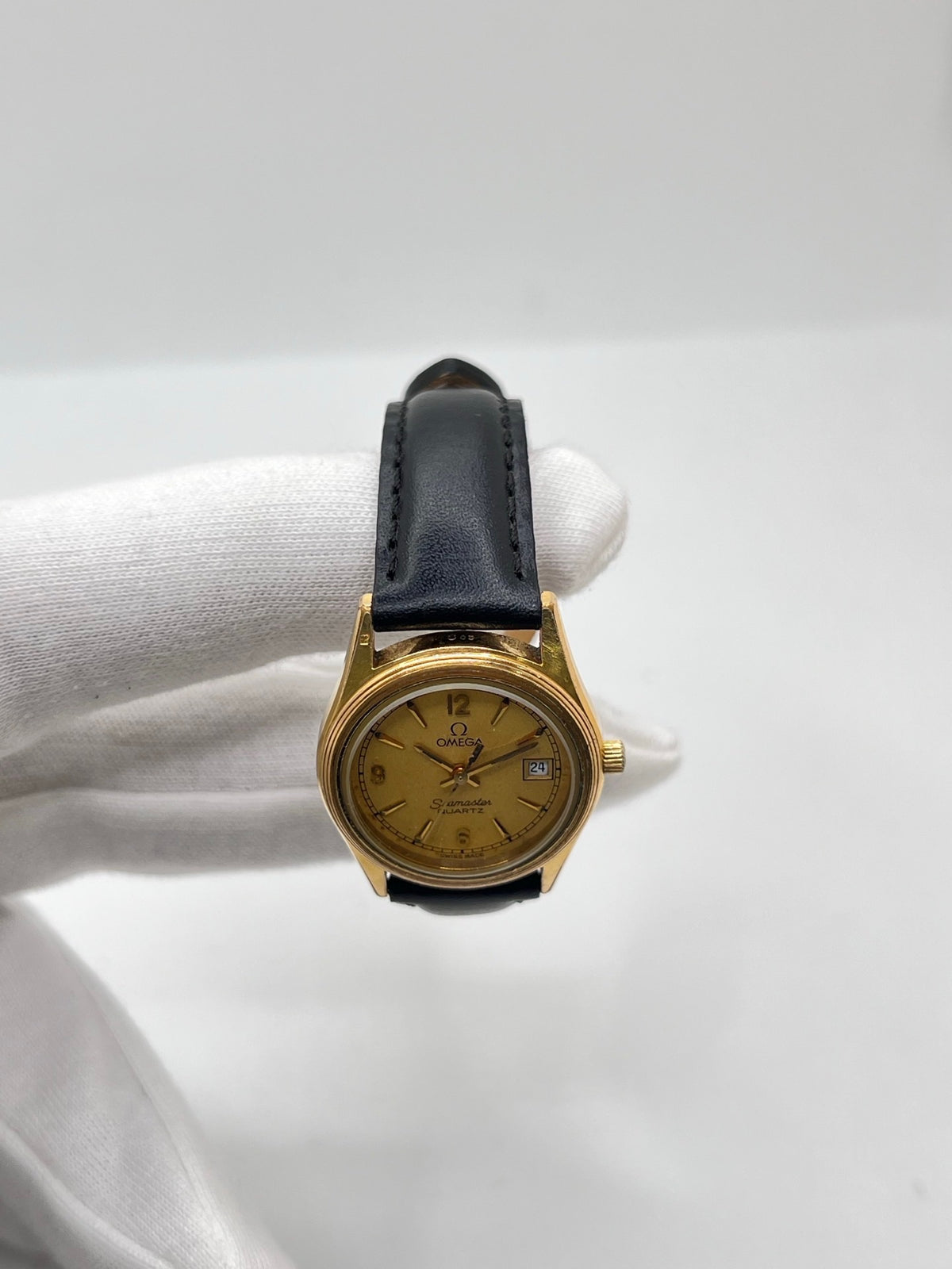 Montre Omega Seamaster 5960035 en très bon état, équipée d’un mouvement quartz et d’un boîtier plaqué or de 25 mm. Son cadran or à chiffres arabes est protégé par un verre saphir. Cette Omega Seamaster possède un bracelet en cuir noir avec boucle ardillon en acier. Destinée aux femmes, cette montre élégante dispose également d’une fonction date et est livrée avec son coffret d’origine. Un modèle intemporel alliant élégance et raffinement.