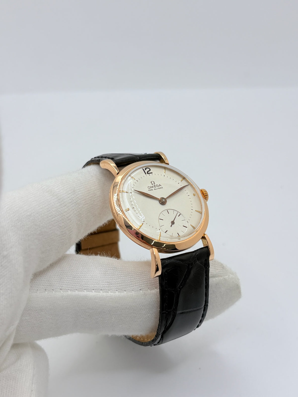 Montre Omega Vintage équipée du célèbre calibre mécanique 30T2 à remontage manuel. Cette montre ancienne, datant approximativement de 1948, présente un boîtier en or rose de 33 mm et un élégant cadran blanc à index bâtons. Son bracelet en cuir de crocodile noir complète son esthétique classique et intemporelle. Cette Omega Vintage calibre 30T2 incarne le charme d’une montre de collection, alliant savoir-faire horloger, élégance et authenticité.
