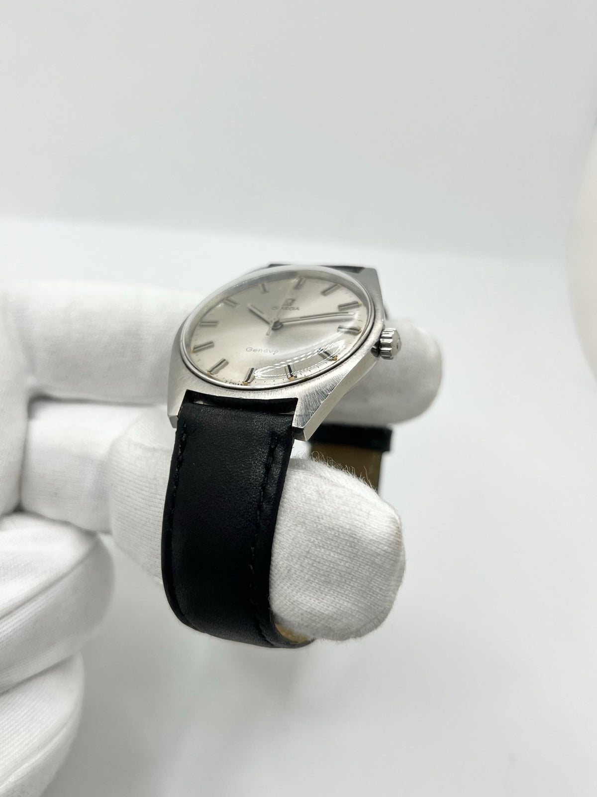 Montre Omega Genève 135.041 vintage de 1969, équipée d’un mouvement à remontage manuel avec calibre 601, offrant une réserve de marche de 48 heures. Son boîtier en acier de 34 mm est associé à un cadran argent à index bâtons, protégé par un verre Plexiglas. Cette Omega Genève est montée sur un bracelet noir en cuir de vache avec boucle ardillon en acier. En bon état, elle présente des traces d’usure visibles.