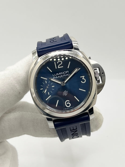Montre Panerai Luminor Base référence PAM 01085 en acier avec boîtier de 44 mm, fabriquée en 2022 et animée par le calibre manufacture P.6000 à remontage manuel offrant 72 heures de réserve de marche. Son cadran bleu à chiffres arabes est protégé par un verre saphir et complété par un bracelet en caoutchouc bleu avec boucle ardillon en acier. Cette montre Panerai d'occasion est en très bon état, révisée en interne et livrée avec son coffret et ses papiers d'origine.