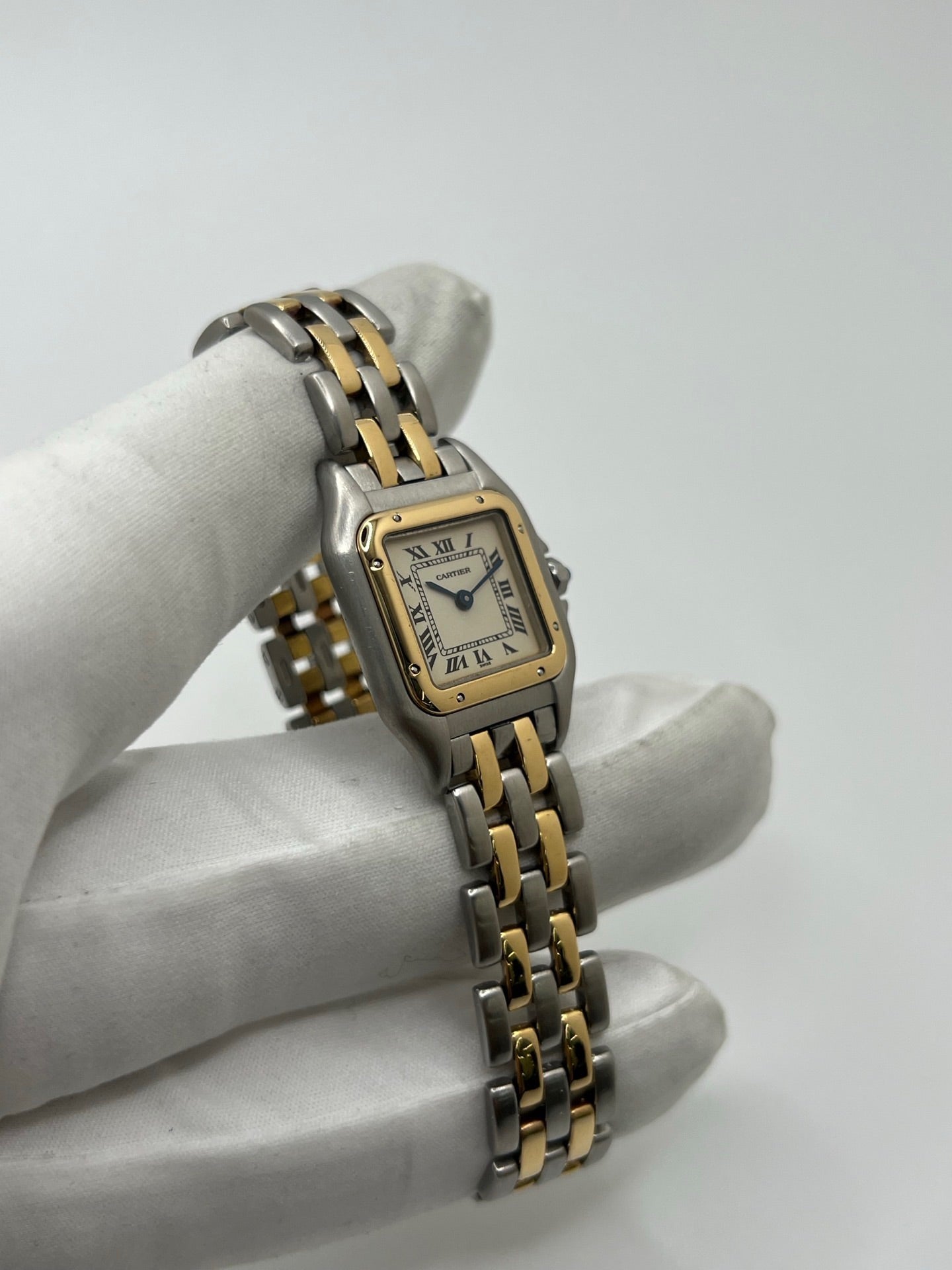 Montre Cartier Panthère 166921 pour femme en or et acier, équipée d’un mouvement quartz suisse. Ce modèle iconique présente un boîtier de 22 x 21 mm, une lunette en or jaune, un cadran blanc à chiffres romains et un verre saphir. Son bracelet en or et acier avec boucle double plis complète son élégance intemporelle. Montre de luxe d’occasion en très bon état, révisée, avec coffret d’origine, idéale pour les amateurs de montres Cartier Panthère femme.