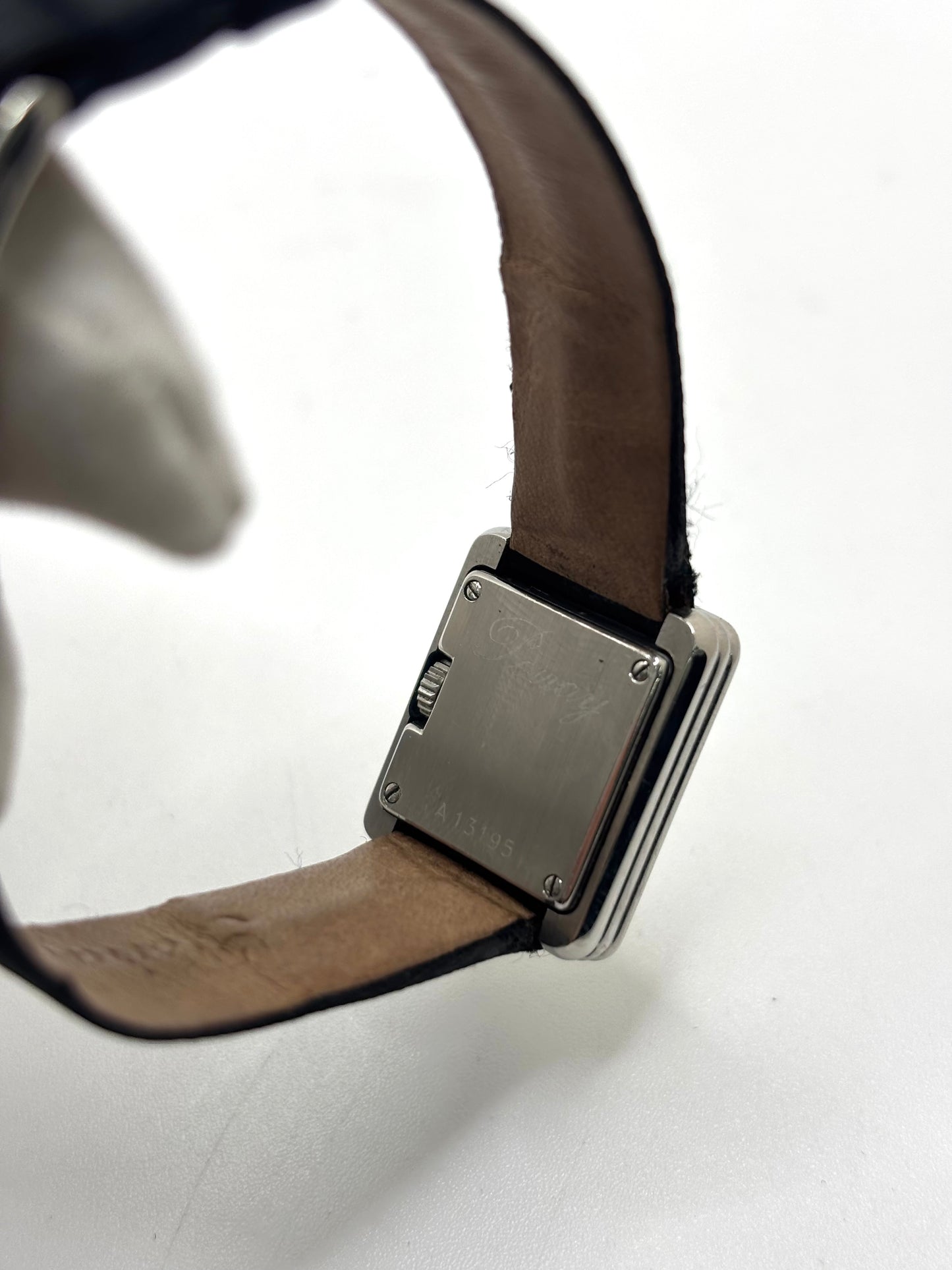 Montre Poiray Ma Première petit modèle en acier avec boîtier de 21,30 × 18,20 mm, cadran blanc épuré sans chiffres et verre minéral. Animée par un mouvement quartz, cette montre femme est équipée de son bracelet textile noir et de sa boucle ardillon d'origine en acier. Révisée, en excellent état et garantie 1 an, cette montre de luxe au style intemporel incarne l'élégance parisienne et le savoir-faire horloger de la maison Poiray.