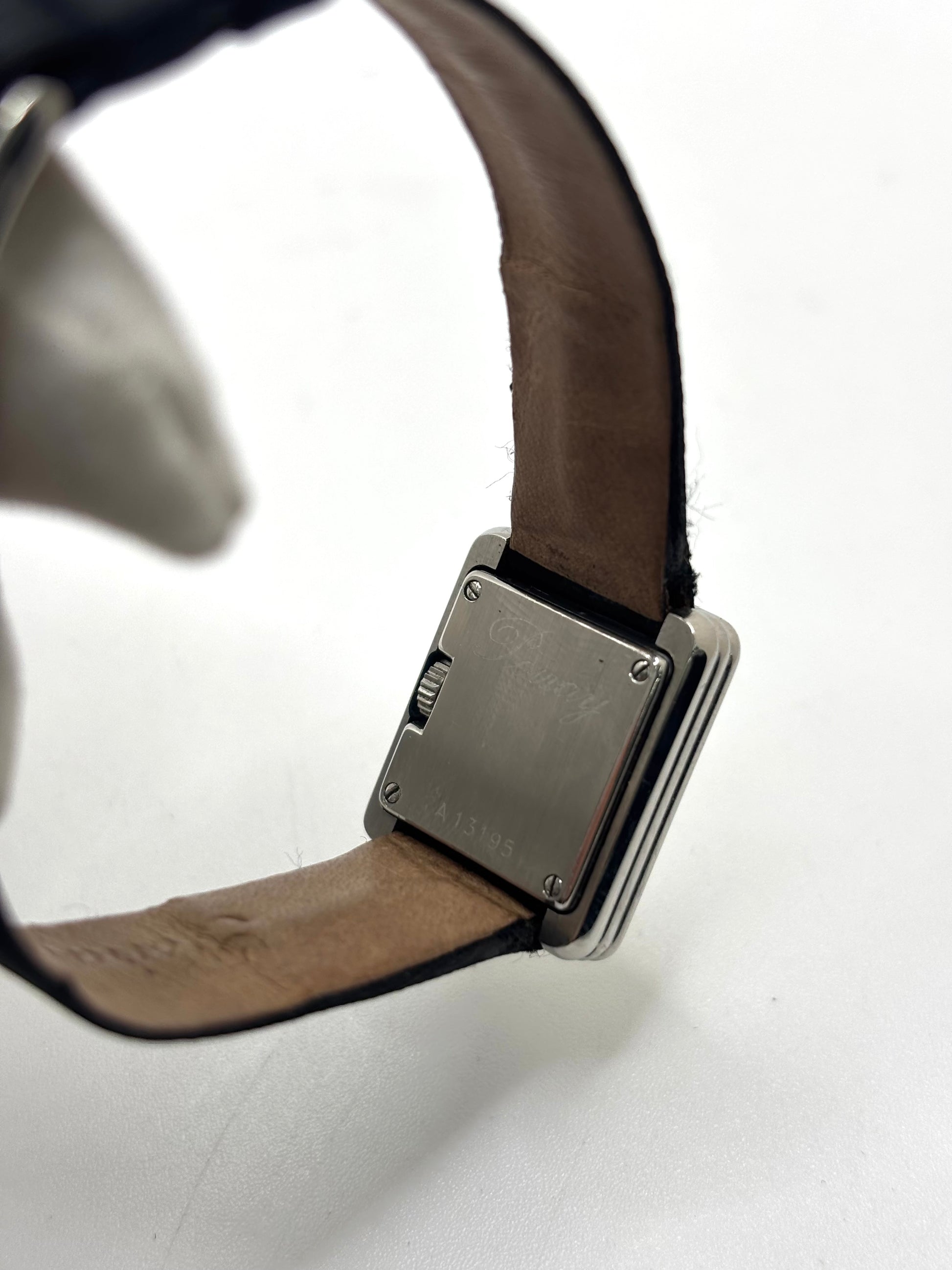 Montre Poiray Ma Première petit modèle en acier avec boîtier de 21,30 × 18,20 mm, cadran blanc épuré sans chiffres et verre minéral. Animée par un mouvement quartz, cette montre femme est équipée de son bracelet textile noir et de sa boucle ardillon d'origine en acier. Révisée, en excellent état et garantie 1 an, cette montre de luxe au style intemporel incarne l'élégance parisienne et le savoir-faire horloger de la maison Poiray.
