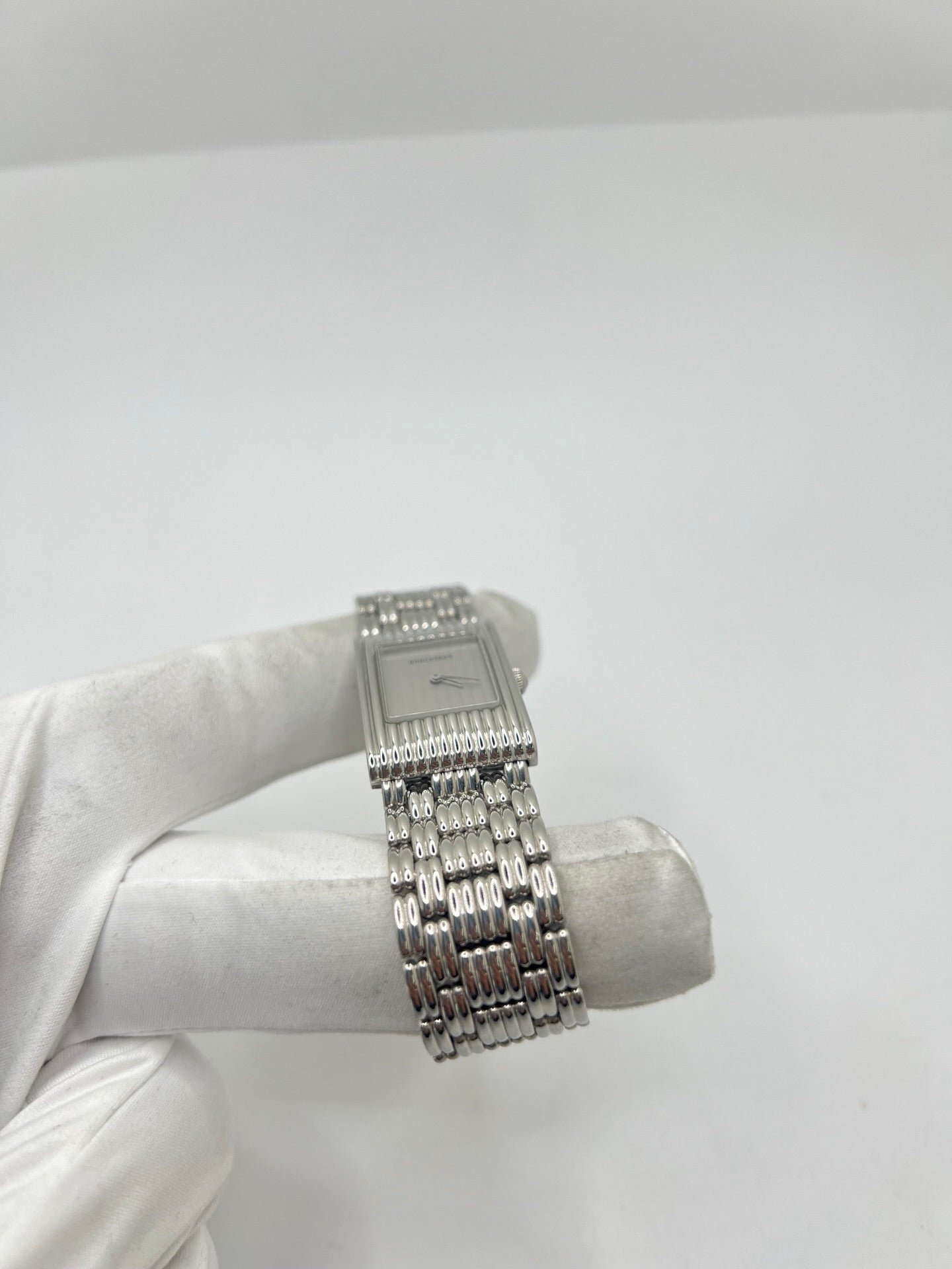 Montre Boucheron Reflet en acier avec mouvement quartz, dotée d’un élégant cadran argent massif sans chiffres et protégée par un verre saphir. Son boîtier rectangulaire de 21 x 32 mm et son bracelet en acier avec boucle double pliant lui confèrent un style raffiné et intemporel. Cette montre de luxe unisexe séduit par ses lignes épurées et son design emblématique, idéal pour les amateurs d’horlogerie et de pièces de prestige d’occasion.
