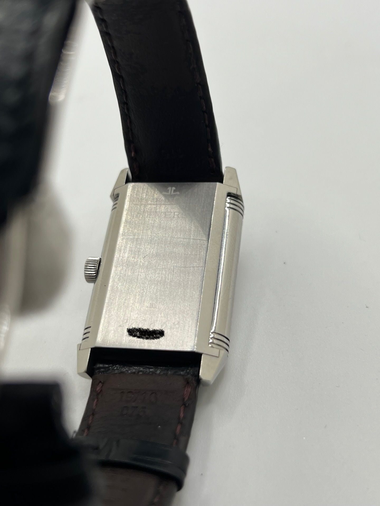 Découvrez la Jaeger-LeCoultre Reverso Grande Taille pour homme/unisexe, modèle 2008 en acier avec bracelet cuir brun. Montre de luxe à remontage manuel, calibre 822, 45 h de réserve de marche, petite seconde et cadran argent. État très bon, avec coffret et papiers d’origine.