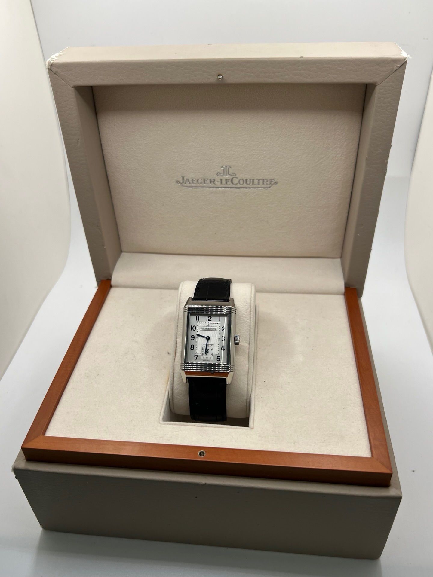 Découvrez la Jaeger-LeCoultre Reverso Grande Taille pour homme/unisexe, modèle 2008 en acier avec bracelet cuir brun. Montre de luxe à remontage manuel, calibre 822, 45 h de réserve de marche, petite seconde et cadran argent. État très bon, avec coffret et papiers d’origine.
