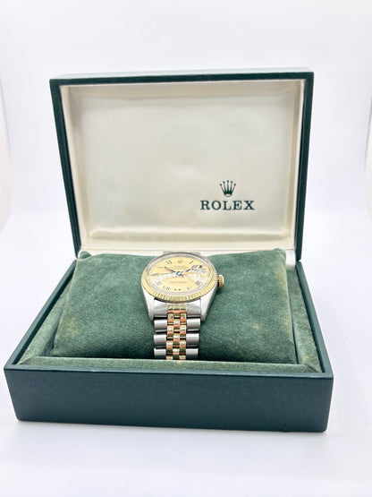 Montre Rolex Datejust 16013 vintage en très bon état, datant de 1979, équipée d’un mouvement automatique calibre 3035 avec 42 heures de réserve de marche. Son boîtier de 36 mm en or et acier possède une lunette en or jaune et un verre Plexiglas. Son cadran or à chiffres romains est accompagné d’un bracelet or et acier. Cette Rolex Datejust dispose également d’une fonction date et d’une étanchéité à 10 ATM.