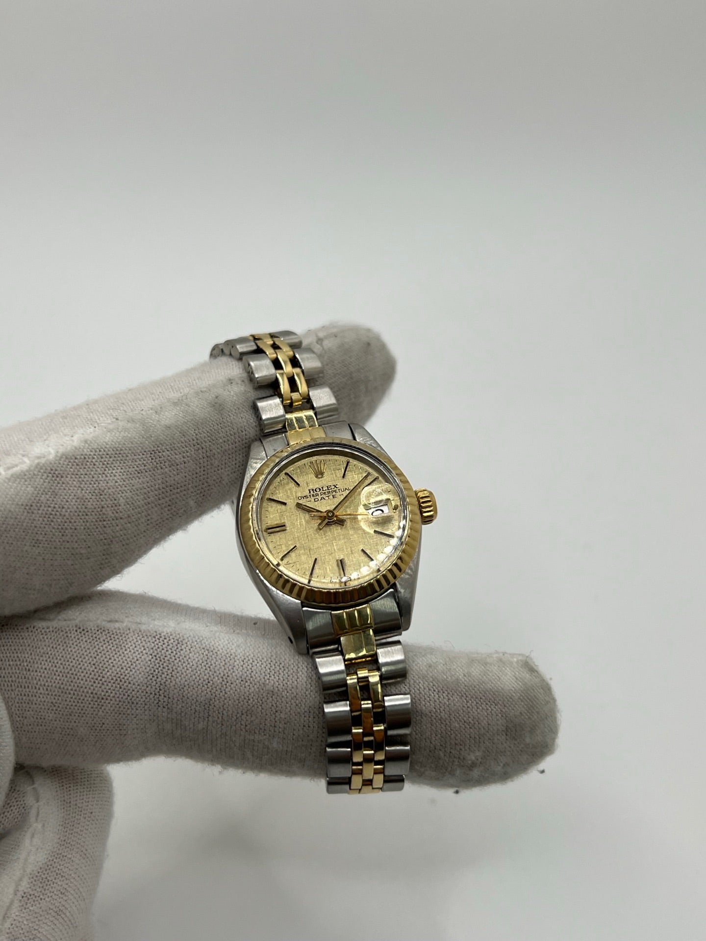 Montre Lady-Datejust référence 69173 en acier et or jaune avec cadran champagne et lunette cannelée en or jaune. Modèle féminin emblématique doté d’un mouvement automatique calibre 2135 et d’un boîtier de 26 mm avec verre saphir. Bracelet bicolore acier et or avec boucle pliante. Montre élégante et intemporelle, appréciée pour son design raffiné et sa fonction date, idéale pour les amateurs de montres classiques et d’horlogerie suisse.