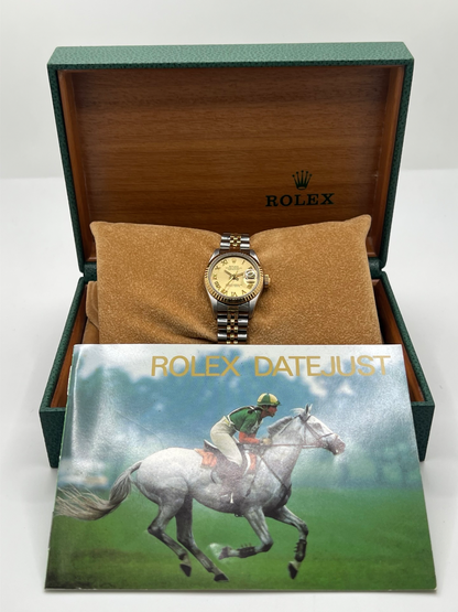 Montre Rolex Lady-Datejust 69173 de 1983 en acier et or jaune avec cadran champagne à chiffres romains, lunette cannelée et bracelet Jubilé. Cette Rolex Lady-Datejust 26 mm automatique est équipée du calibre Rolex 2135 avec affichage de la date et verre saphir. Élégante et intemporelle, cette Rolex femme vintage associe raffinement et confort grâce à son bracelet iconique acier et or. Montre livrée avec boîte d’origine, certificat d’authenticité et garantie 1 an.