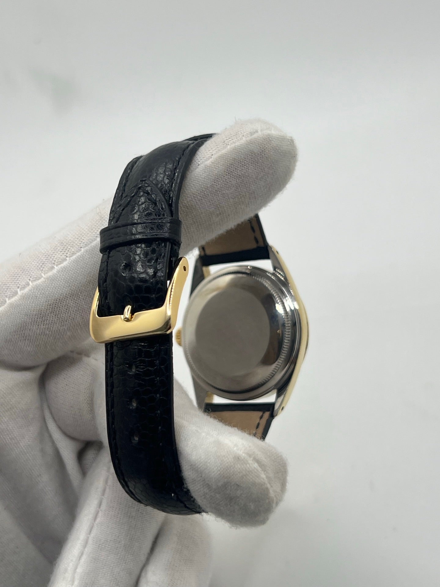 Montre Rolex Oyster Perpetual Date vintage en plaqué or, calibre automatique 1570 avec 26 pierres, cadran or et chiffres bâtons, boîtier de 34 mm, verre plexiglas. Bracelet en cuir de lézard noir avec boucle en acier. Fonction date, révision récente effectuée, coffret d’origine inclus, modèle homme/unisexe, état très bon avec légères traces d’usure.