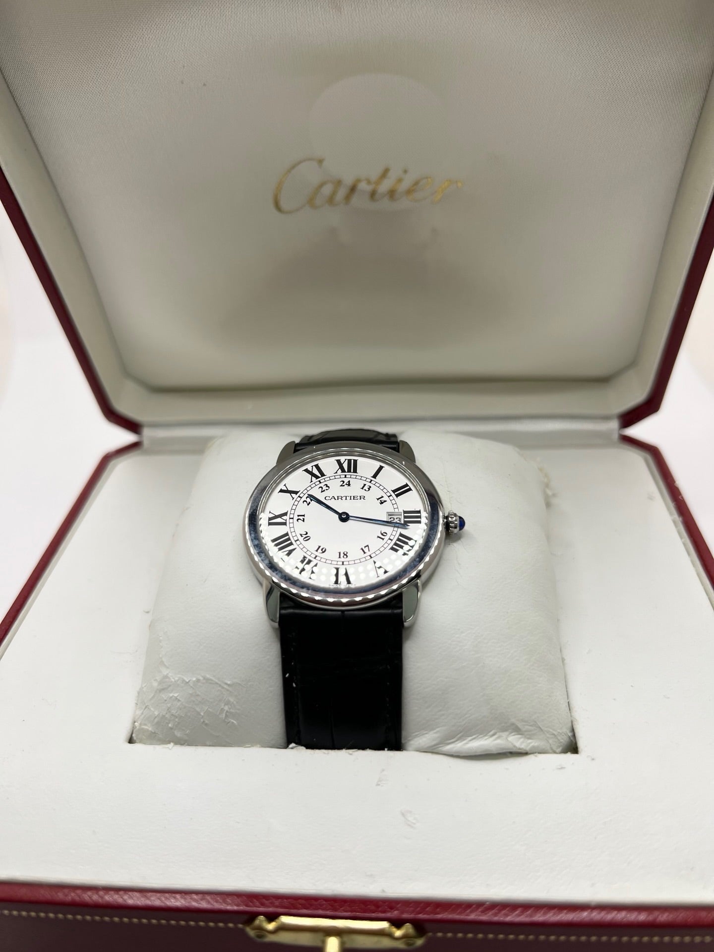 Montre Cartier Ronde Solo en acier avec cadran argent à chiffres romains, mouvement quartz et fonction date. Boîtier rond 36 x 39 mm avec verre saphir et étanchéité 3 ATM. Bracelet en cuir noir avec boucle ardillon en acier. Design classique et élégant, idéal pour homme ou unisexe. Montre d’occasion en très bon état, révisée, avec coffret d’origine.