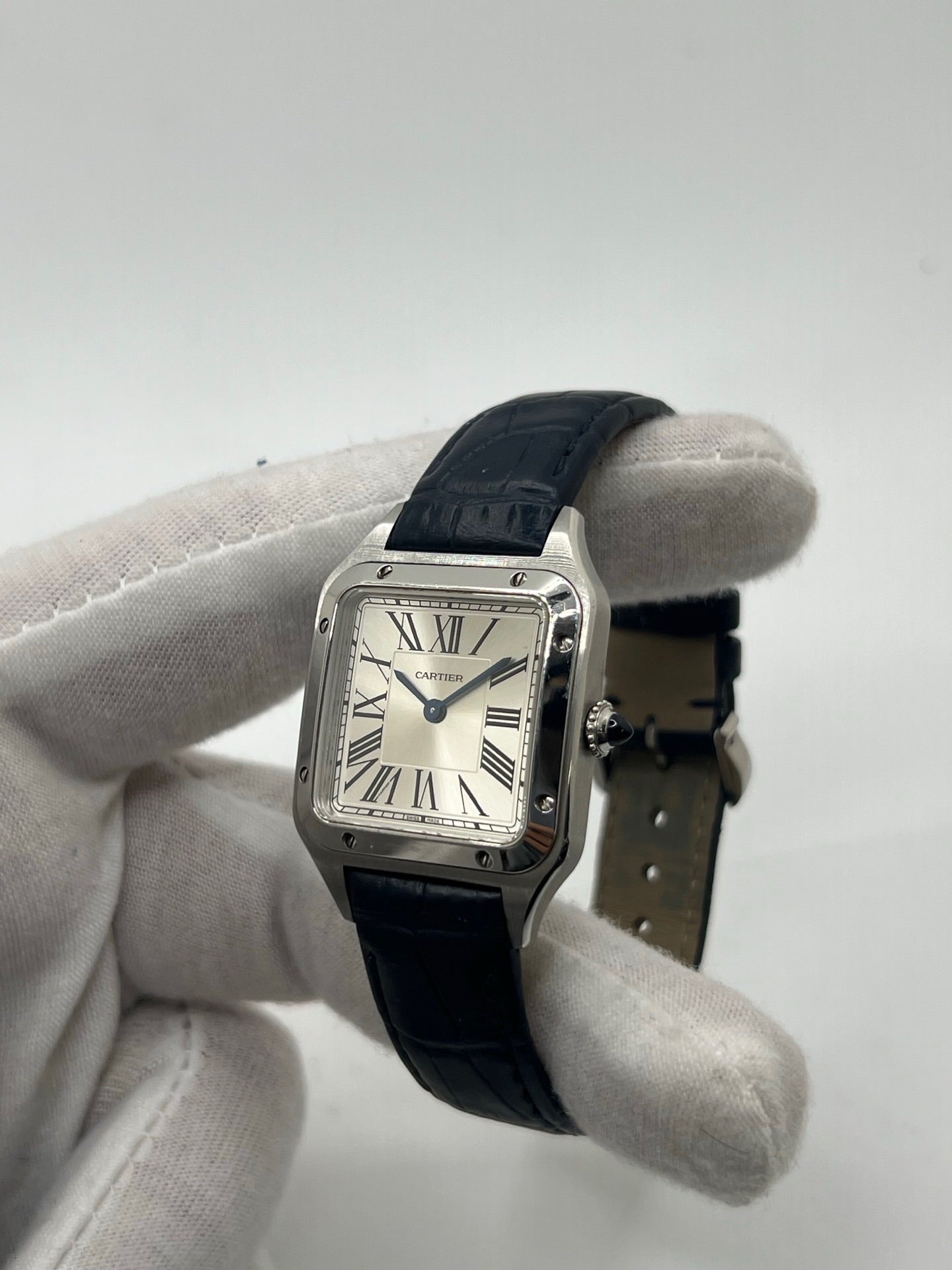 Montre élégante Santos Dumont en acier avec cadran argent et chiffres romains, équipée d’un mouvement quartz précis. Bracelet en cuir de crocodile bleu avec boucle ardillon en acier. Boîtier 38 x 27,5 mm, verre saphir et étanchéité 3 ATM. Design raffiné, idéal pour un style classique et sophistiqué. Disponible avec coffret et papiers d’origine.