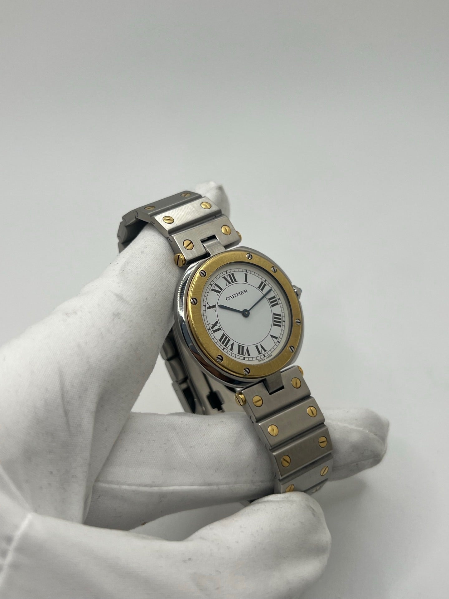 Montre Cartier Santos Ronde d'occasion en très bon état, boîtier or/acier de 33 mm avec lunette en or jaune et cadran blanc à chiffres romains. Mouvement quartz précis, verre saphir résistant aux rayures. Bracelet assorti or/acier avec boucle du même matériau. Livrée avec coffret d’origine, sans papiers. Parfaite pour collectionneurs ou amateurs de montres élégantes, disponible en stock à Paris, prix négociable