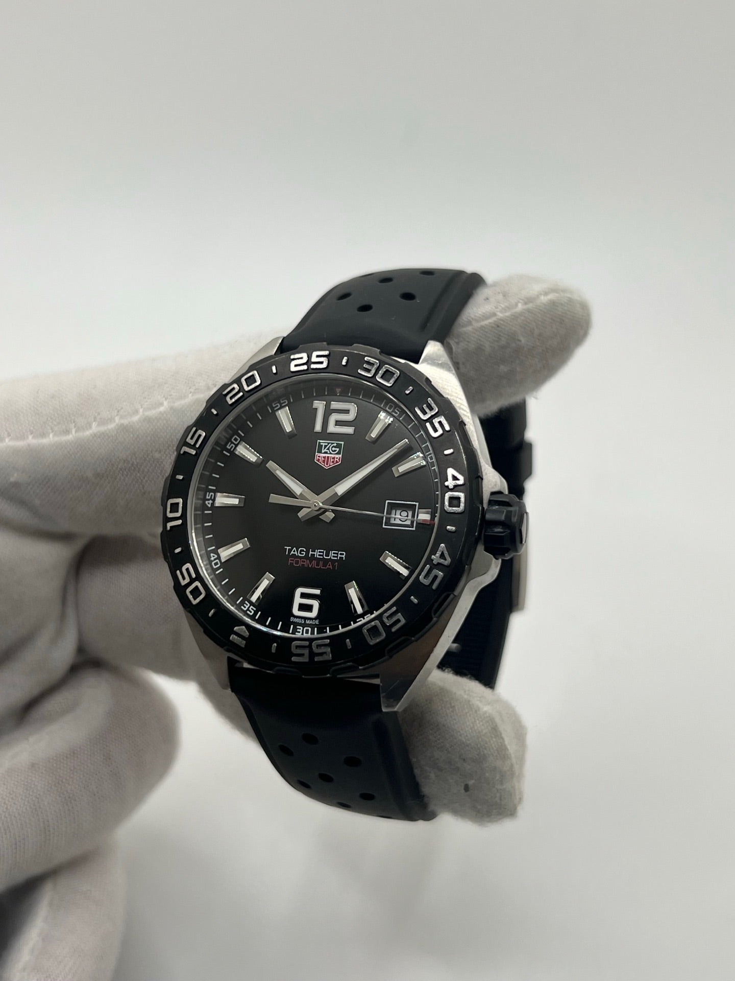 Montre TAG Heuer Formula 1 Quartz référence WAZ1110 avec boîtier en acier de 41 mm, cadran noir et verre saphir résistant aux rayures. Modèle sportif étanche à 200 mètres, équipé d’un bracelet en caoutchouc noir avec boucle déployante en acier. Cette montre homme ou unisexe d’occasion présente des traces d’usure visibles, révisée en février 2026, idéale pour un usage quotidien ou une collection horlogère sportive.