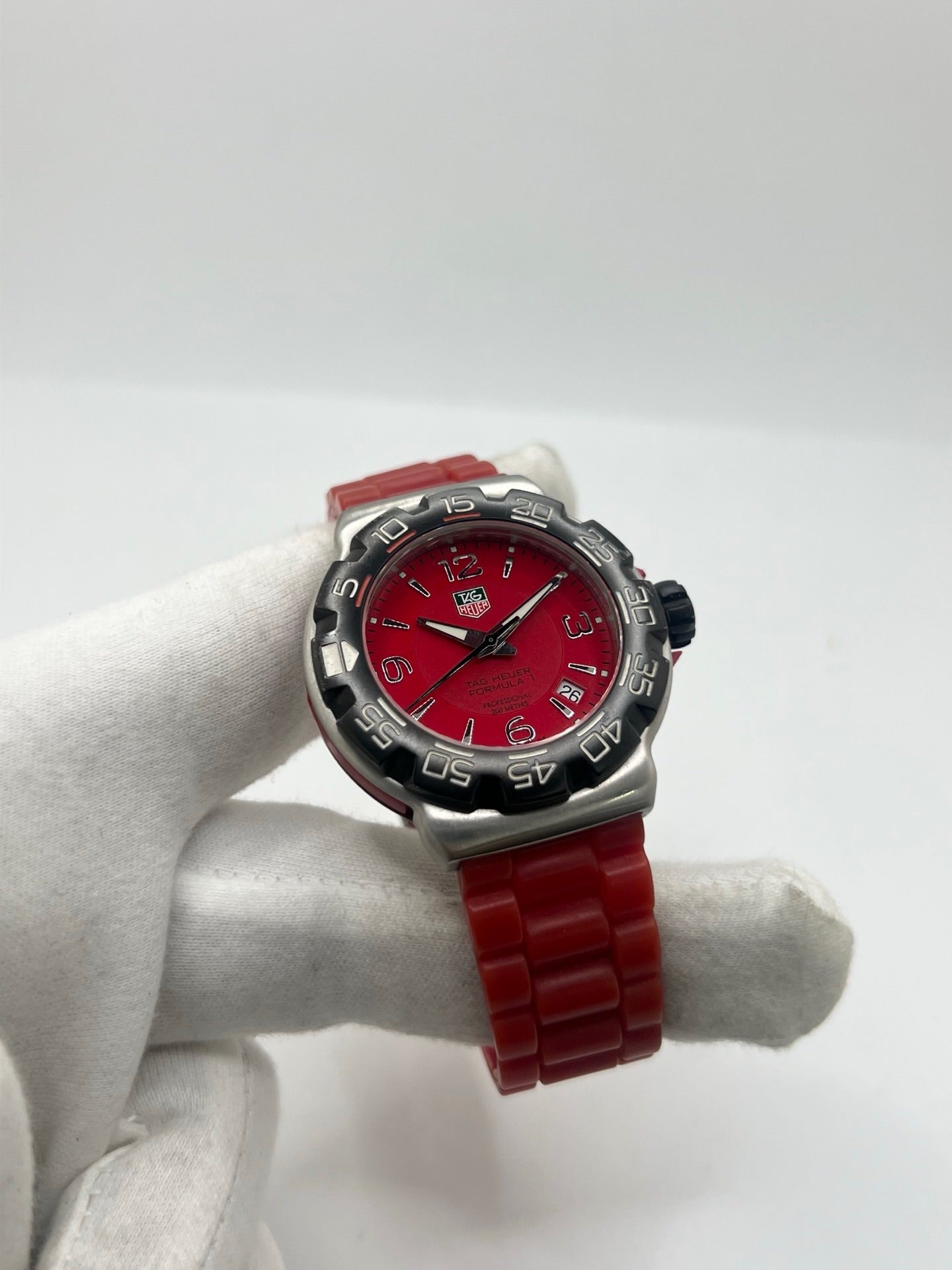 Montre TAG Heuer Formula 1 Quartz réf. WAC1113-0 en acier avec mouvement à quartz, cadran rouge à chiffres arabes et lunette en céramique. Son boîtier de 40 mm est associé à un bracelet en caoutchouc rouge avec boucle ardillon en acier, offrant un style sportif et un excellent confort. Cette TAG Heuer Formula 1 d'occasion est en très bon état, révisée en interne et disponible immédiatement. Elle dispose également d'un affichage de la date.