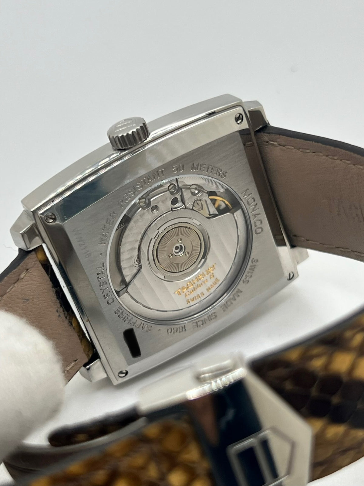 Montre TAG Heuer Monaco Calibre 6 WW2115 pour homme, équipée d’un mouvement automatique offrant une réserve de marche de 42 heures et du calibre 6 doté de 27 pierres. Son boîtier en acier de 37 mm accueille un cadran brun au style élégant et distinctif. Cette TAG Heuer Monaco est montée sur un bracelet en cuir de serpent avec boucle déployante en acier. Dotée d’un affichage de la date, elle allie design emblématique et savoir-faire horloger. Vendue avec son coffret d’origine, en très bon état.